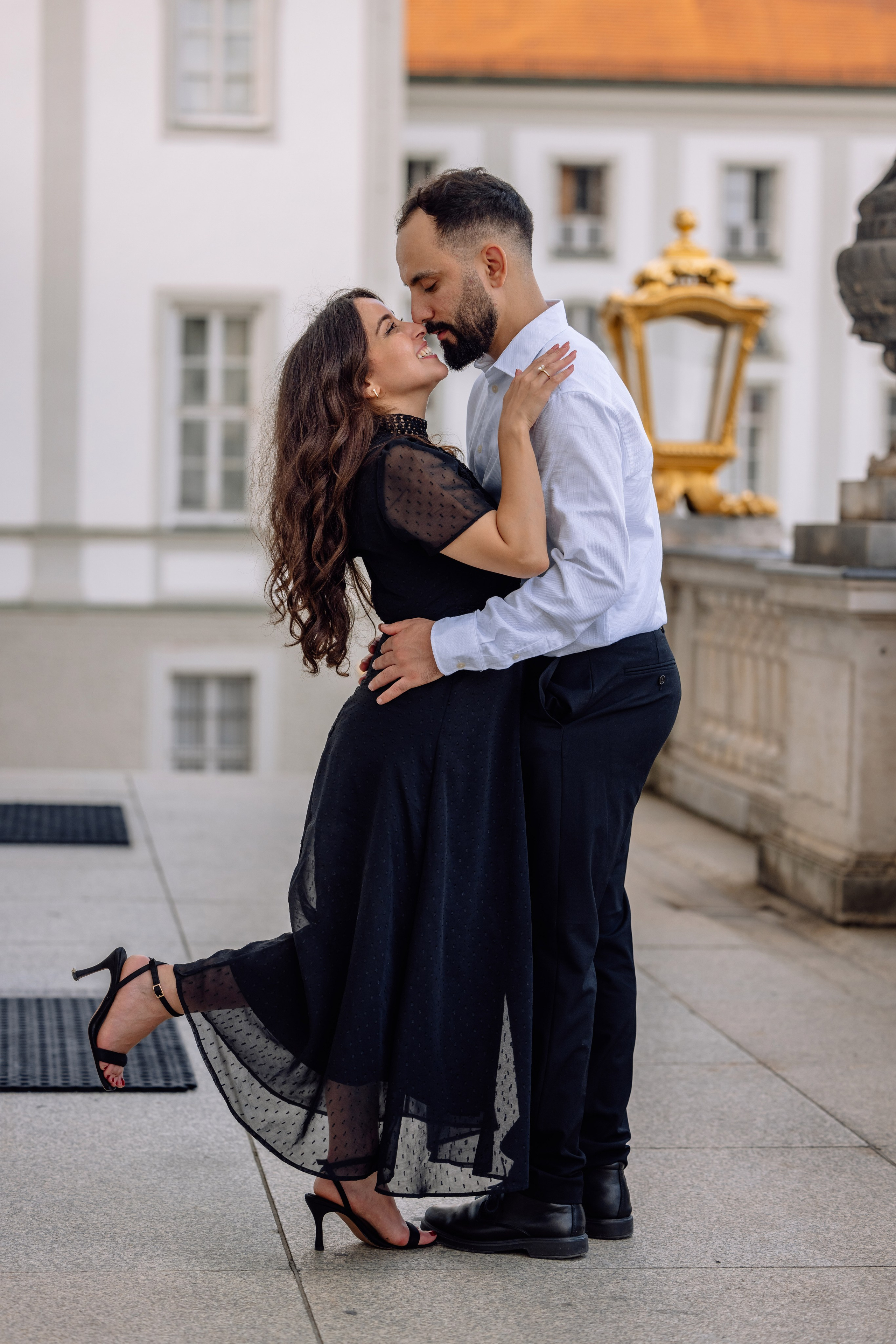 Braut und Bräutigam küssen sich leidenschaftlich vor dem Schloss Nymphenburg