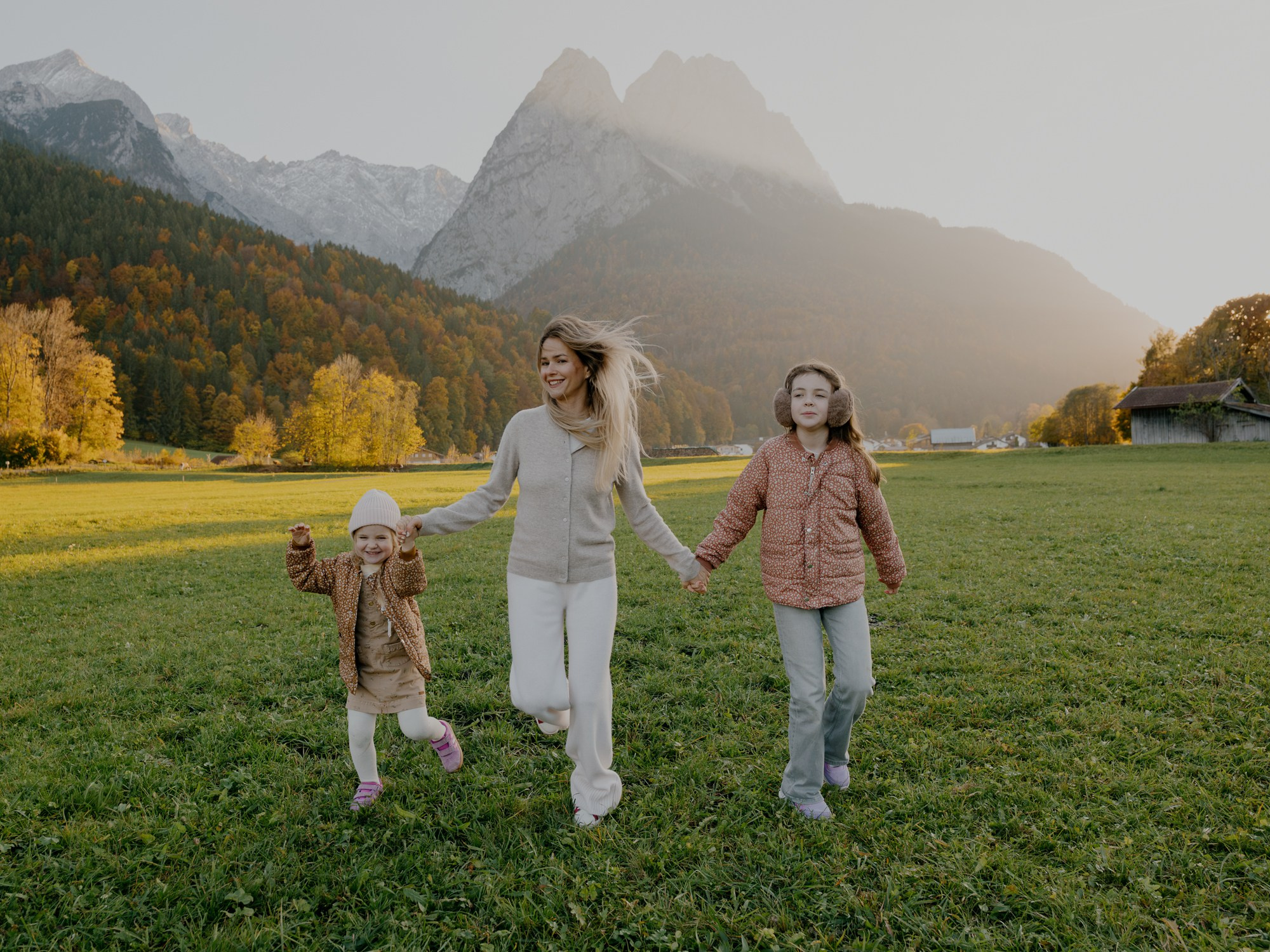 Children walking hand-in-hand on a path with mountains in the background in Garmisch-Partenkirchen and Grainau