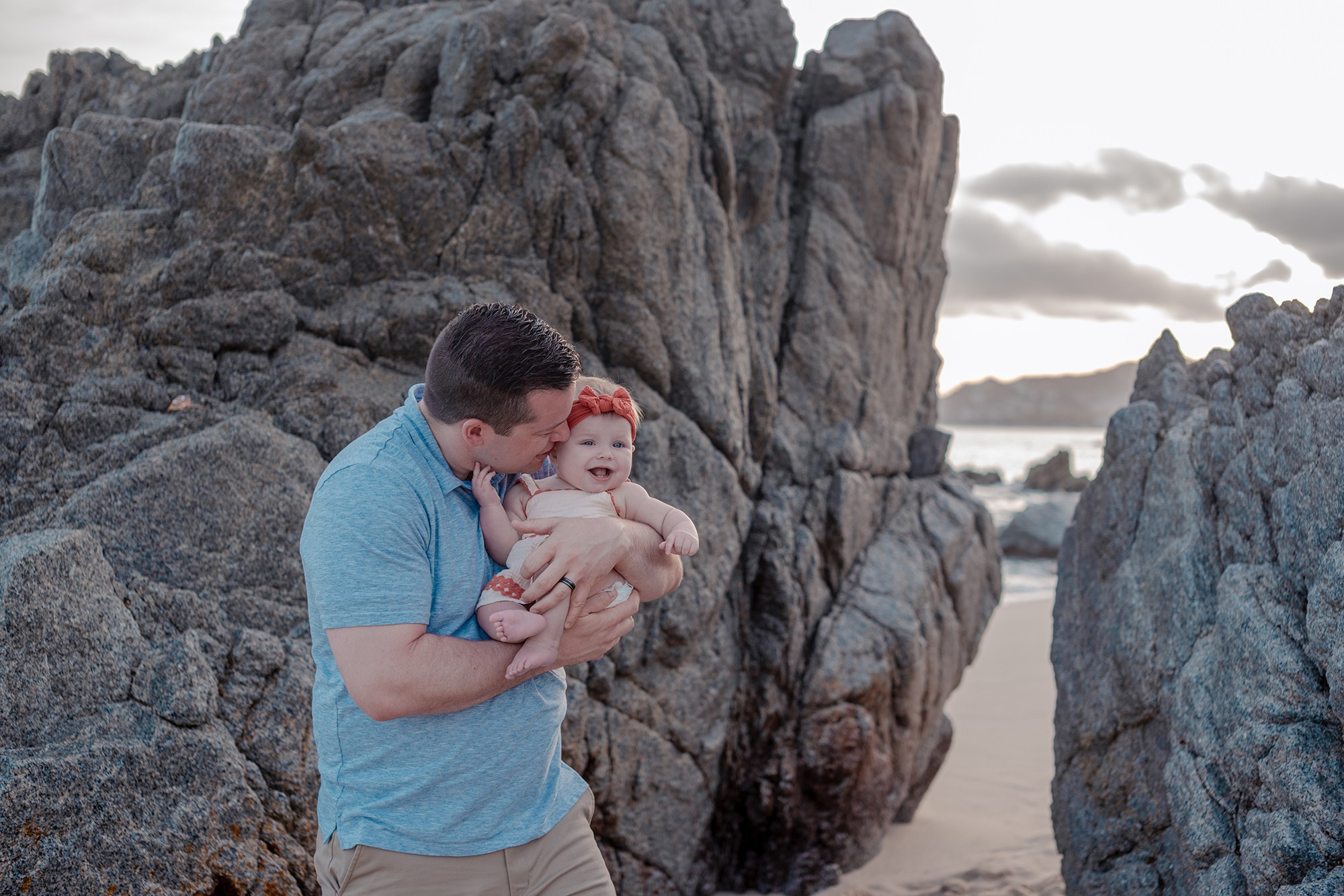 Parents and baby with grandmother enjoying a relaxed family photo session on Playa Monumentos Cabo San Lucas