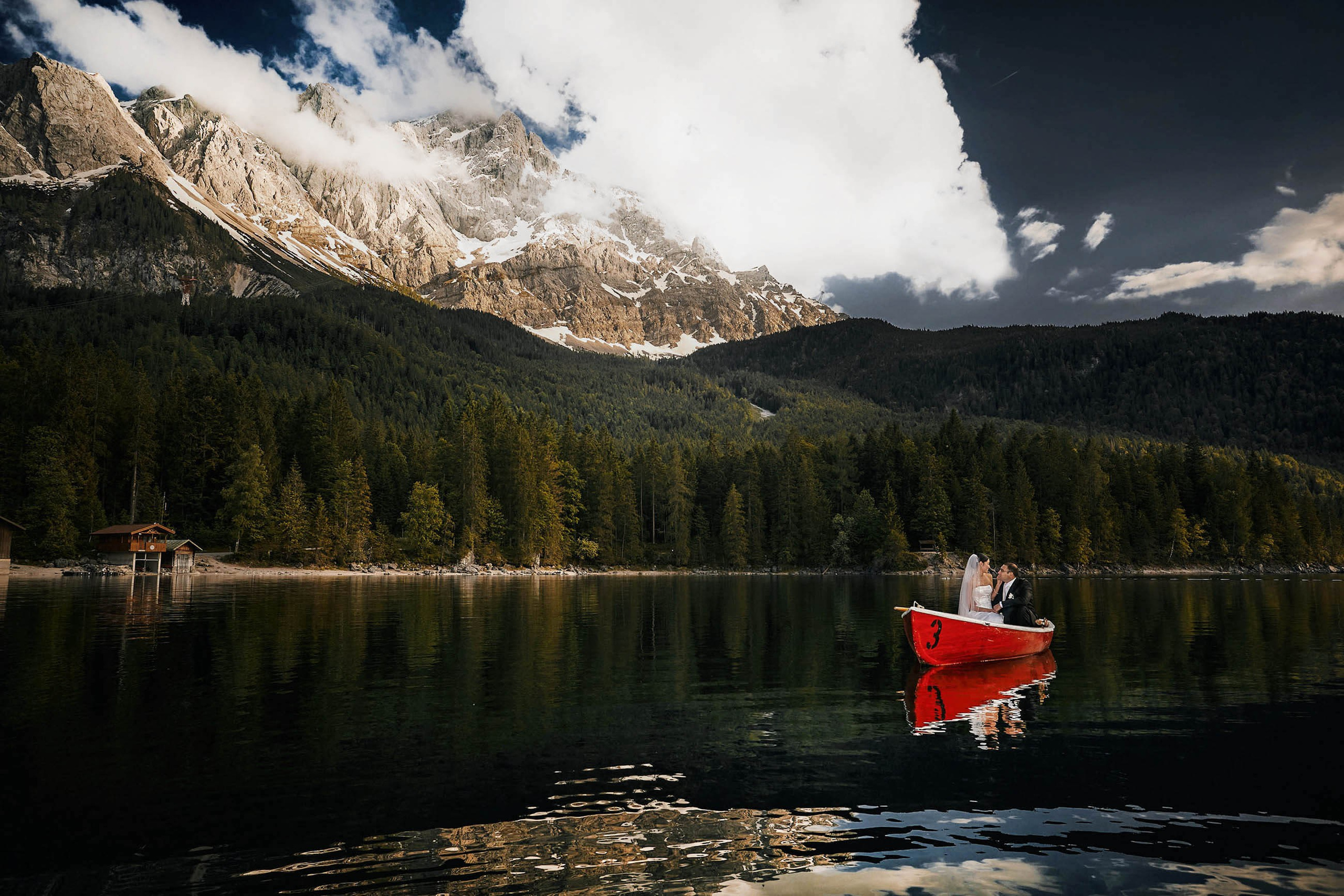 A bride & groom from America enjoys the quiet solitude of Lake Eibsee during their wedding day in Germany.  
