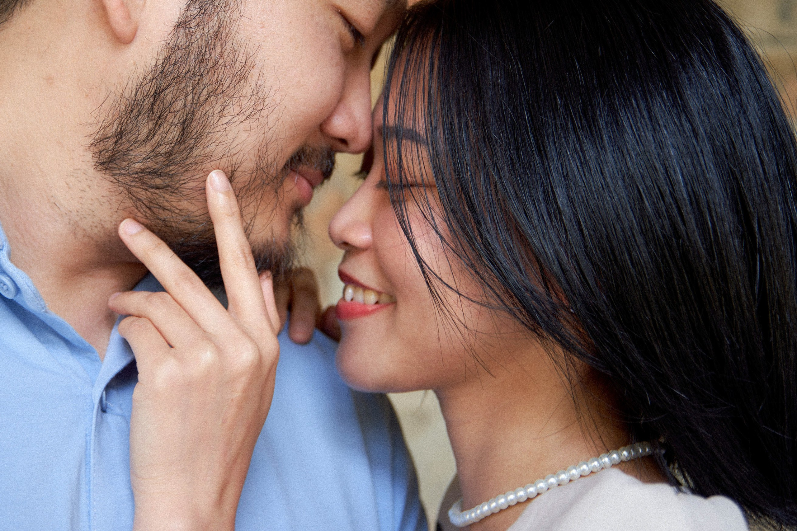 Woman tenderly stroking her partner's face in the historic Sala Terrena of Vrtba Garden, Prague.