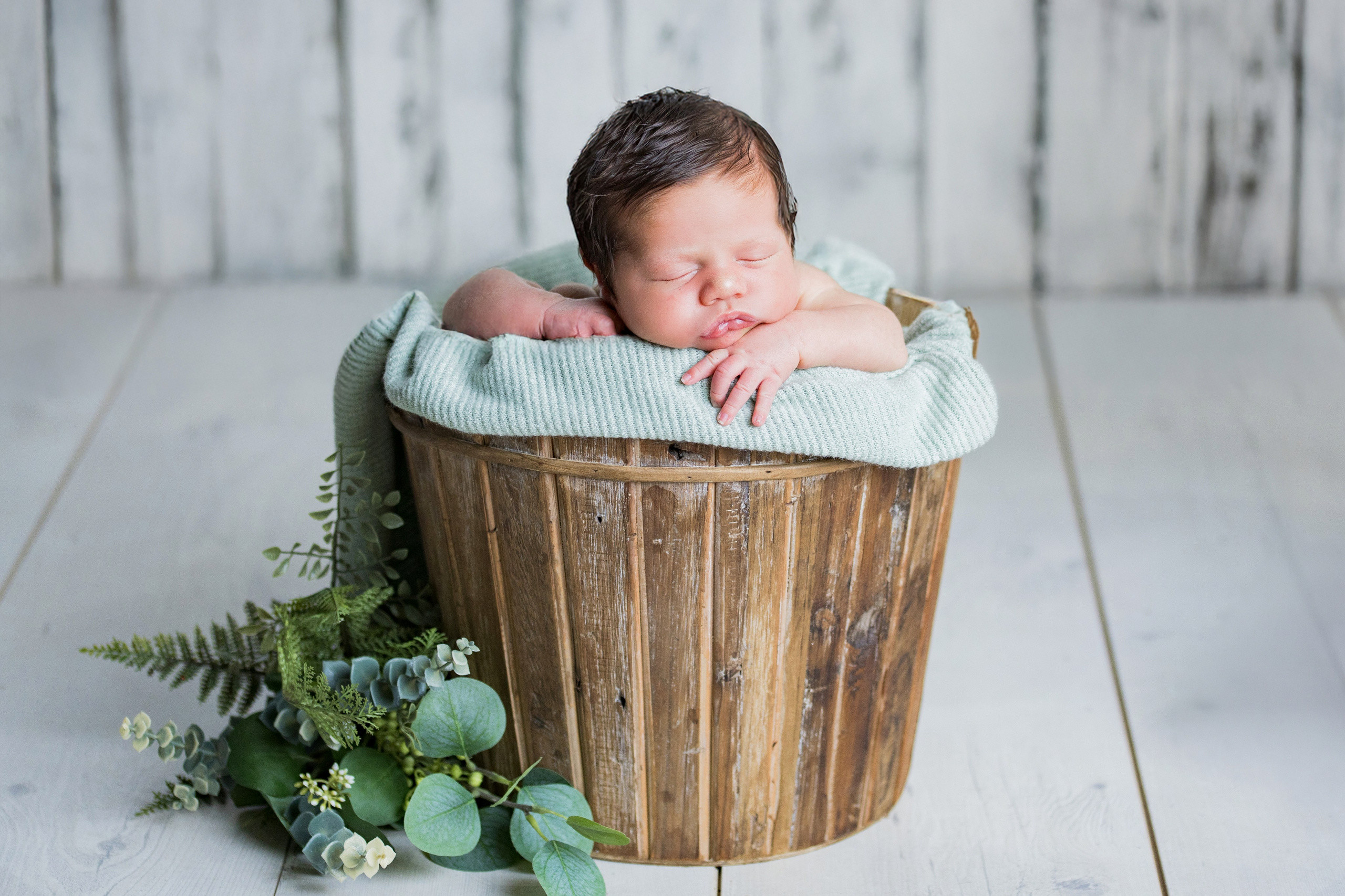 Fotografía de bebé recién nacido estilo minimalista, luz natural y sombras suaves para resaltar la pureza del bebé.