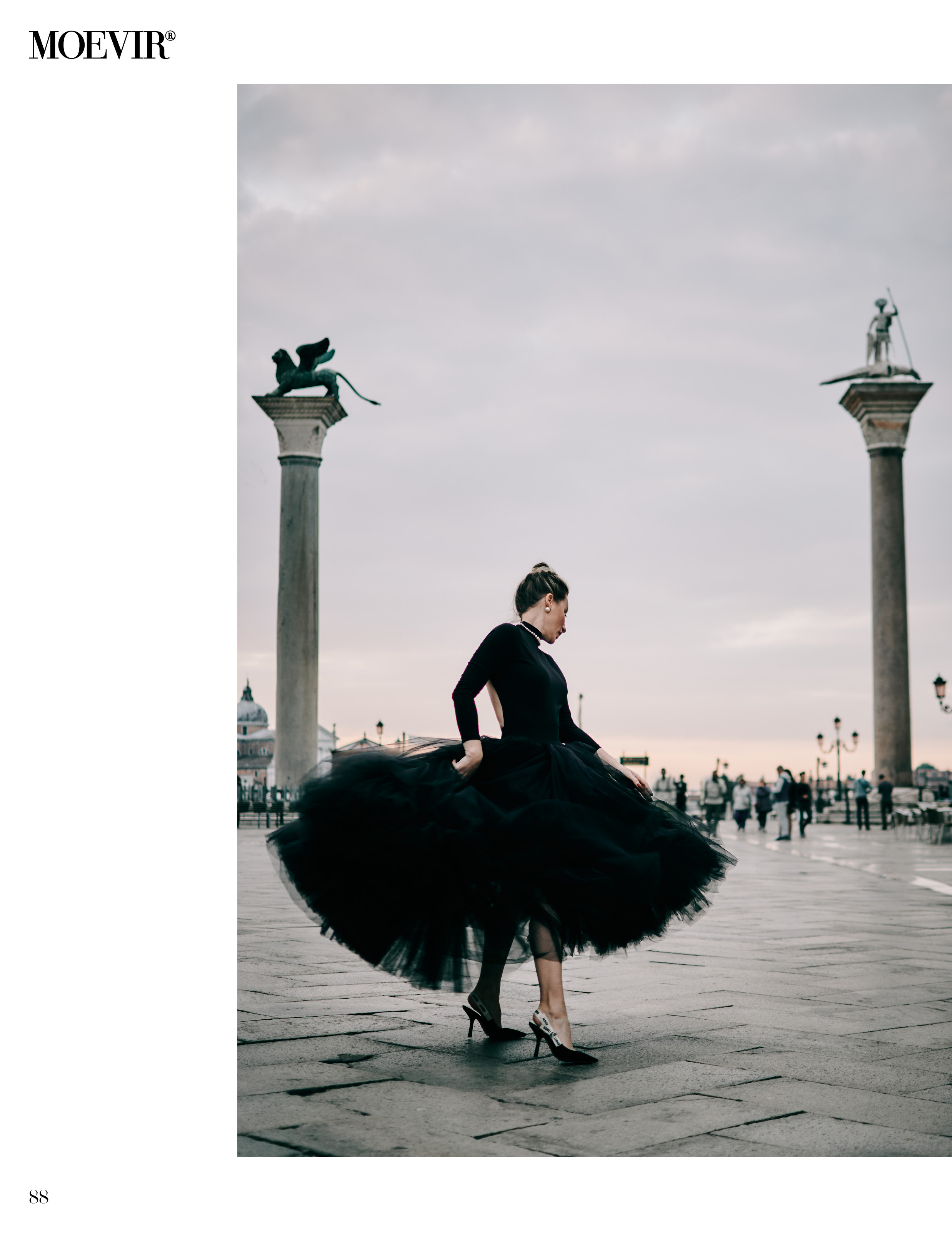 A young woman stands tall in front of the grand Columns of San Marco and San Todaro on the iconic San Marco Square in Venice. The woman's long hair flows freely in the gentle breeze as she gazes gracefully into the distance. The towering columns, adorned with intricate carvings, frame the woman beautifully, creating a striking contrast between the ancient architecture and the woman's youthful appearance. The warm, golden light of the setting sun bathes the scene, casting a soft glow on the woman's face and the majestic columns behind her.