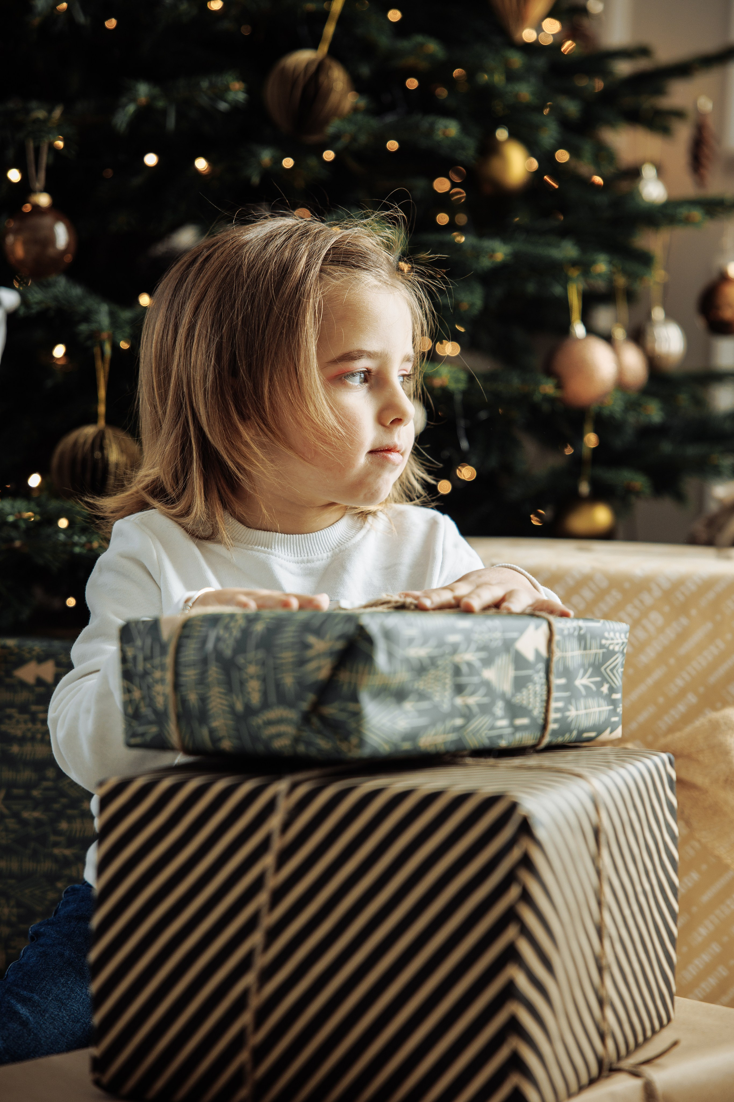 Little girl with presents under the Christmas tree 