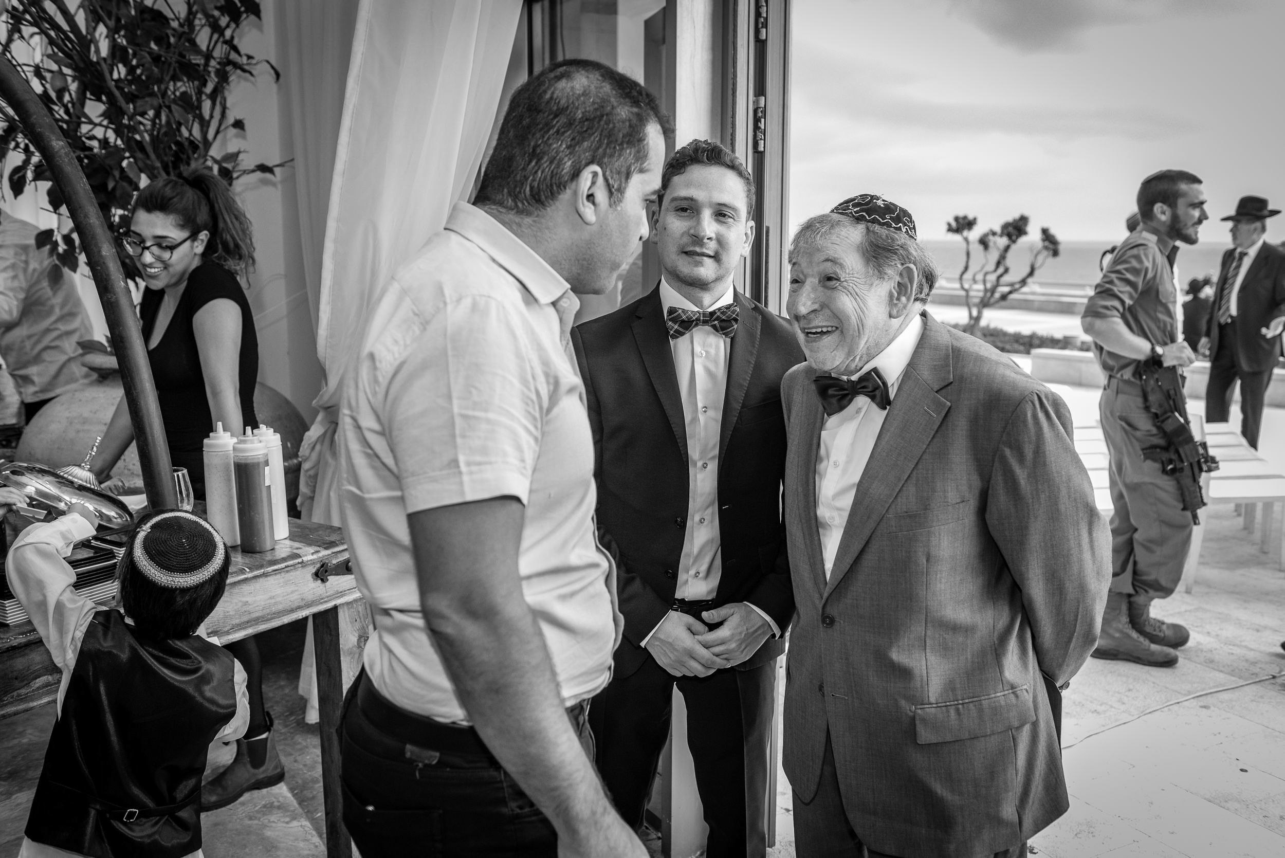 Wedding guests sharing a candid moment during a cocktail reception at the Leonardo Hotel in Haifa, Israel