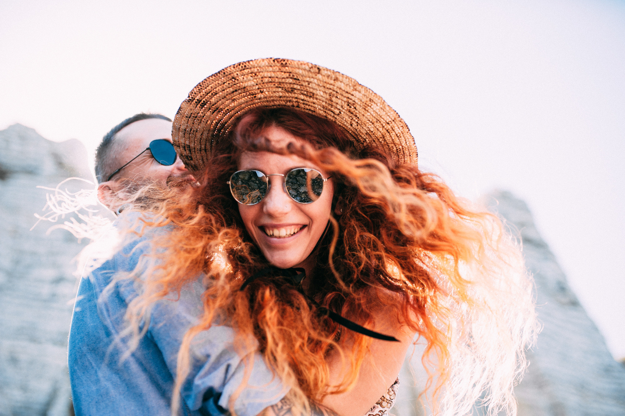a woman with long hair and a straw hat