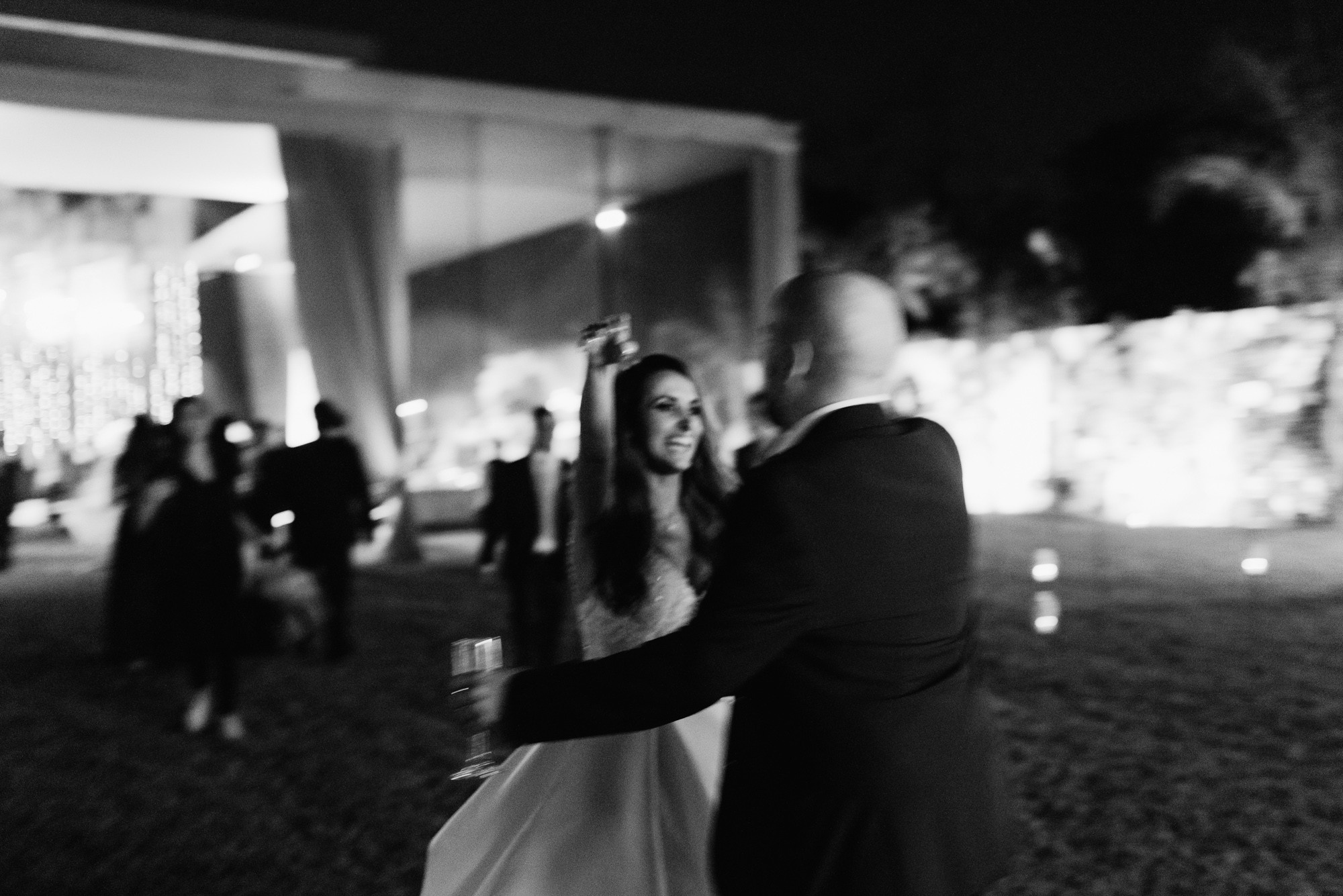 a bride and groom dance in the night