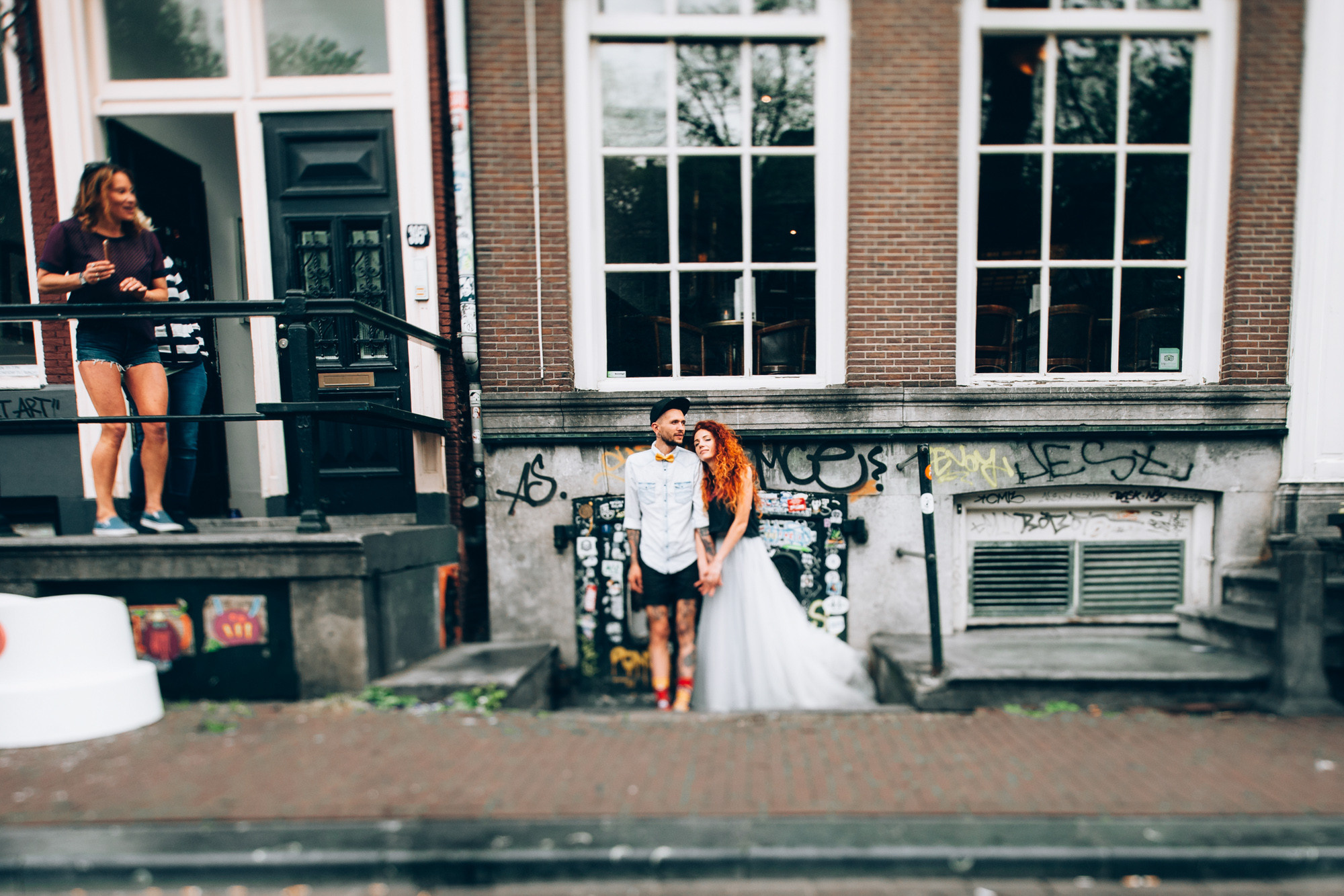 a couple standing on a balcony next to a building