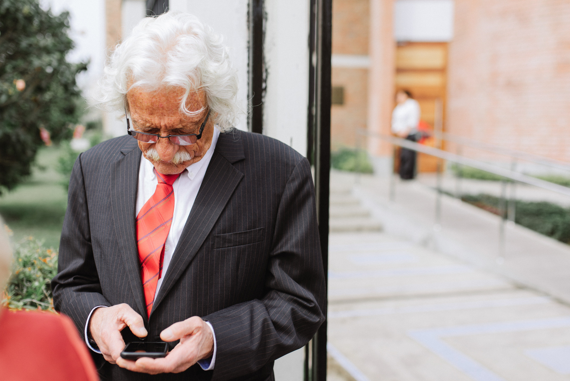 a man in a suit and tie looking at his cell