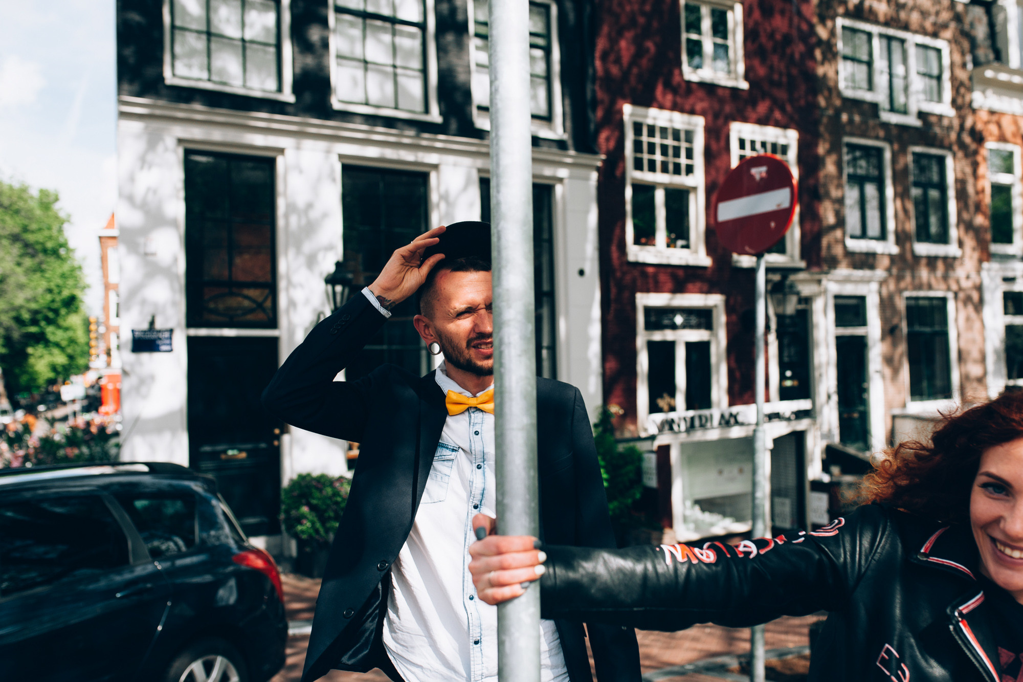 a man and woman standing next to a stop sign