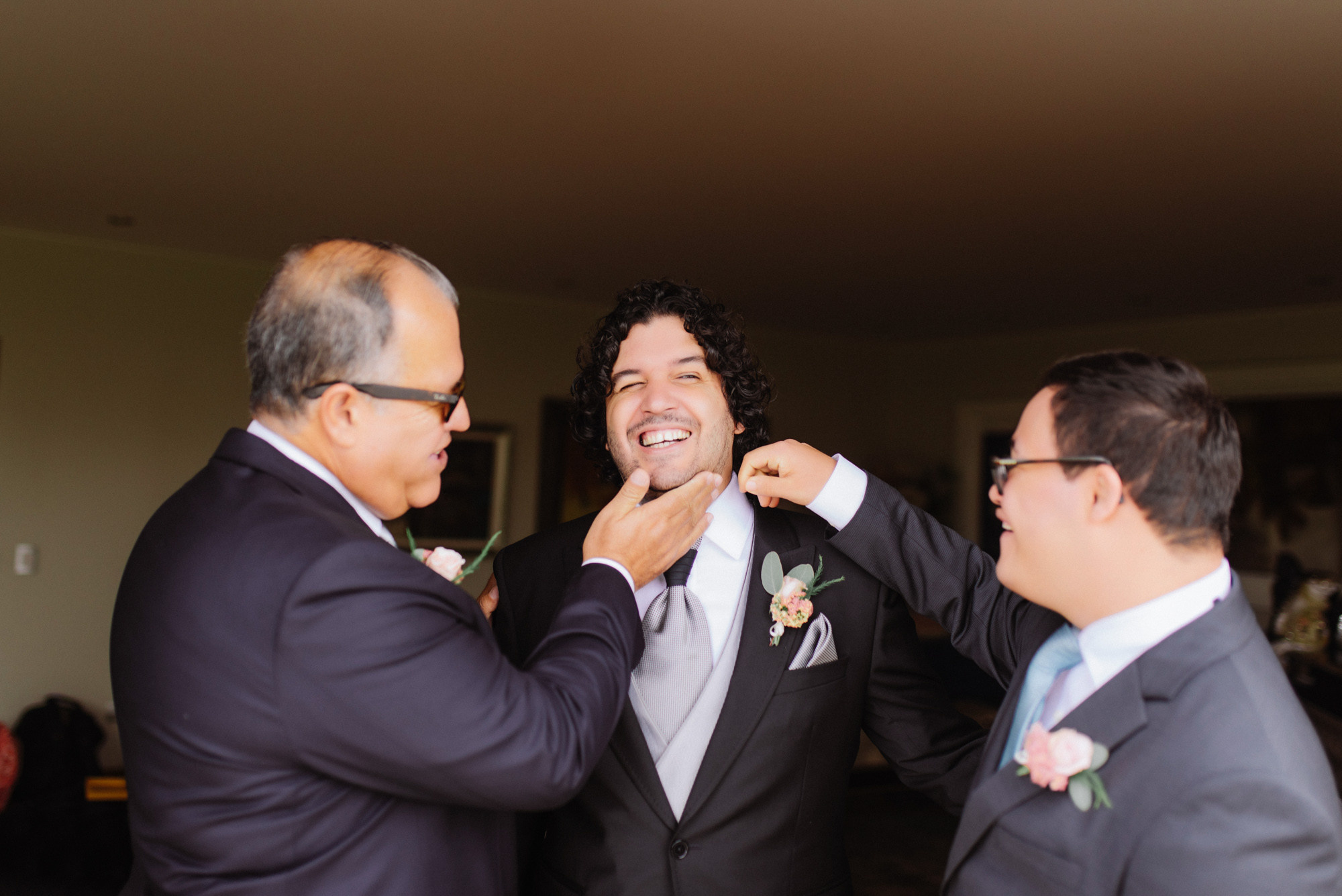 a man in a suit fixing another man's tie