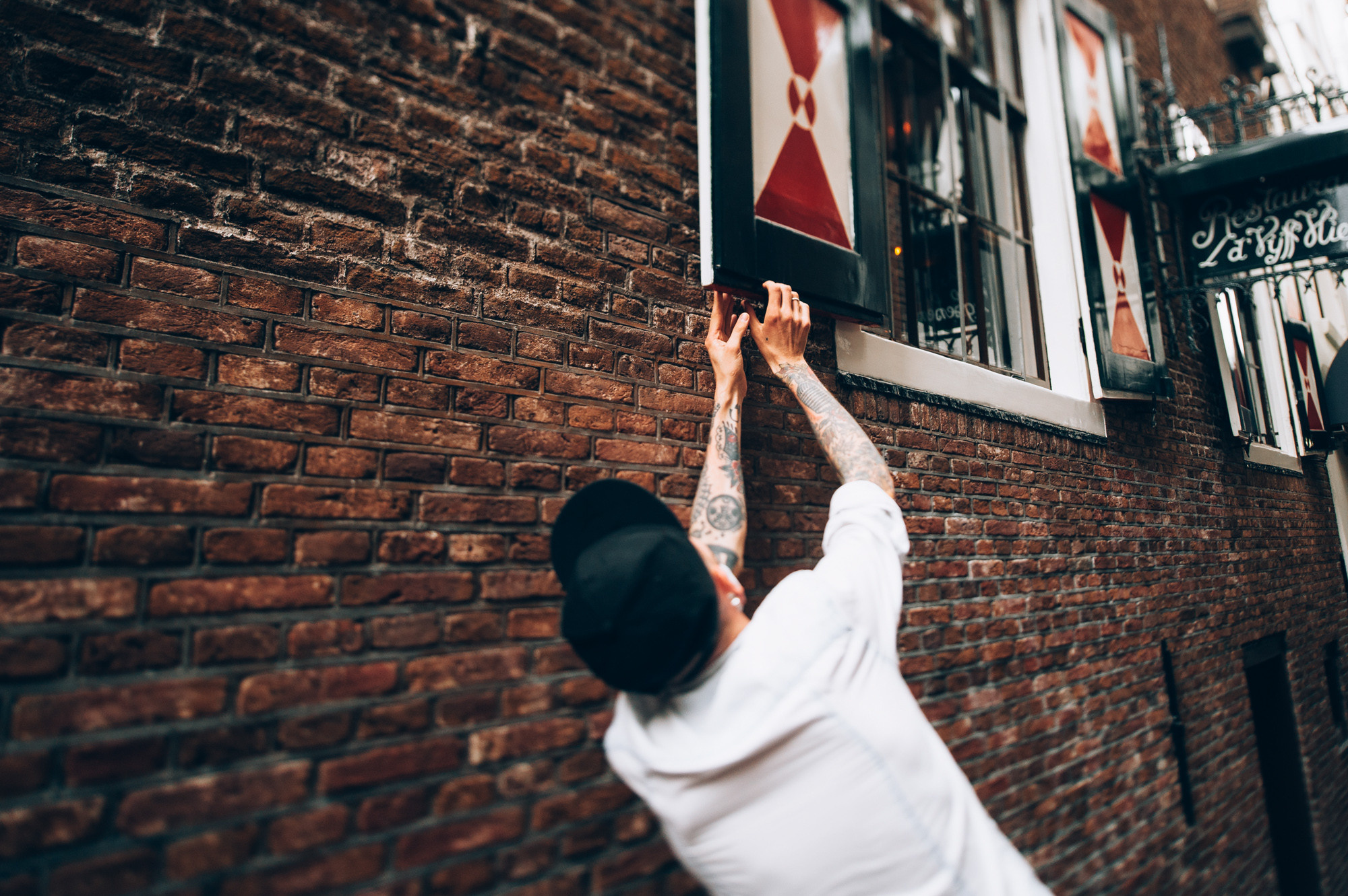 a man reaching up to a brick wall