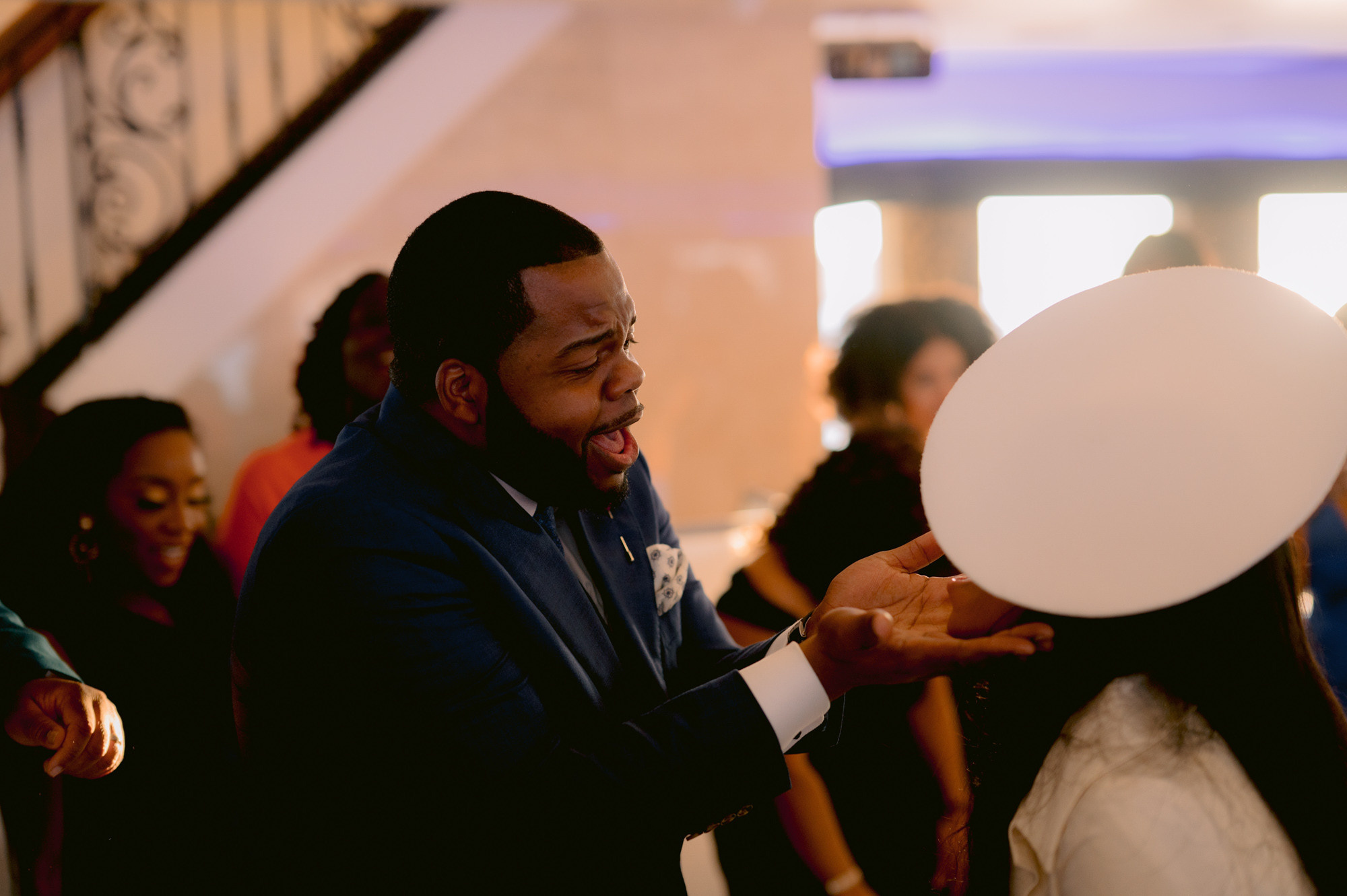a man holding a white balloon in a crowd