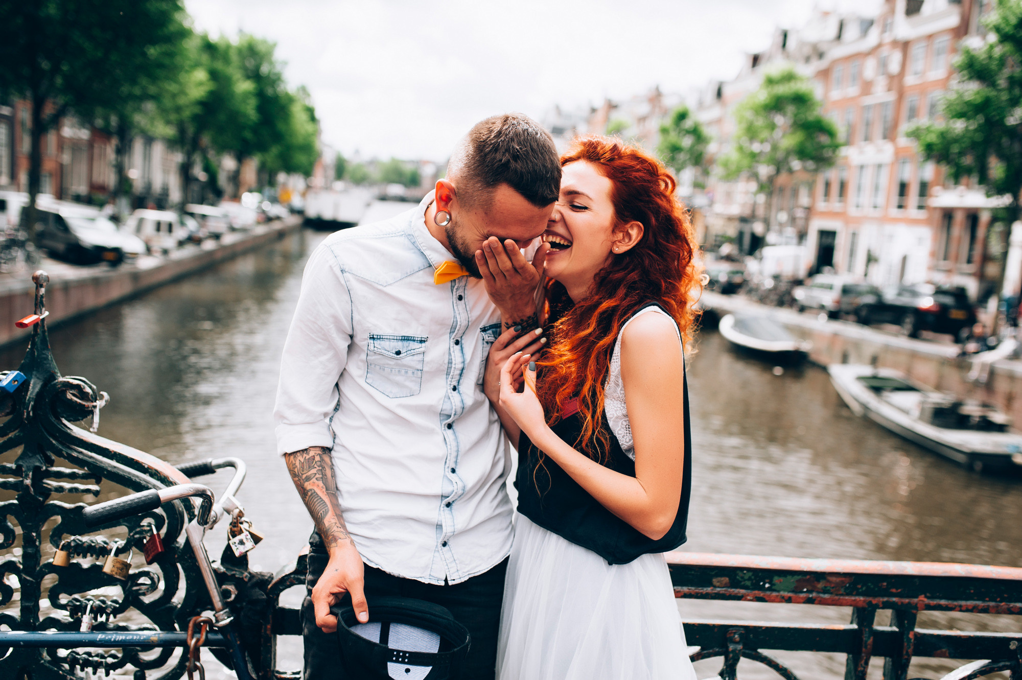 a man and woman kissing on a bridge