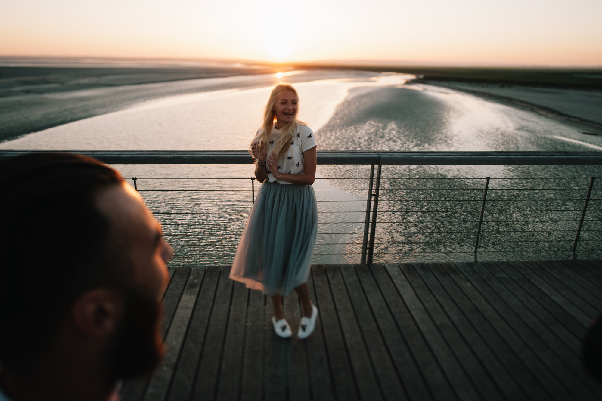 a woman standing on a dock next to a man
