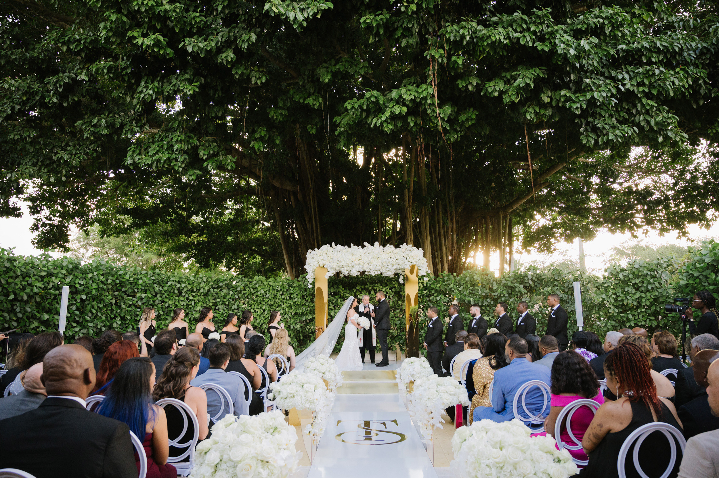 a wedding ceremony with a couple sitting at the end of the aisle