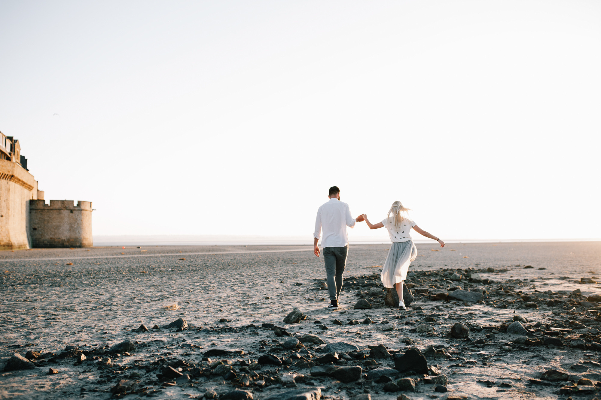a man and woman walking on a beach