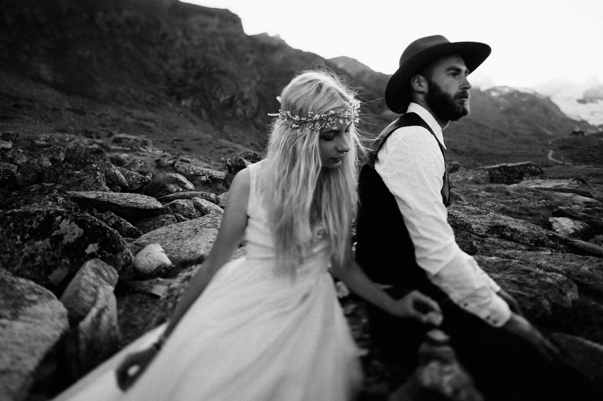 a man and woman are standing on rocks