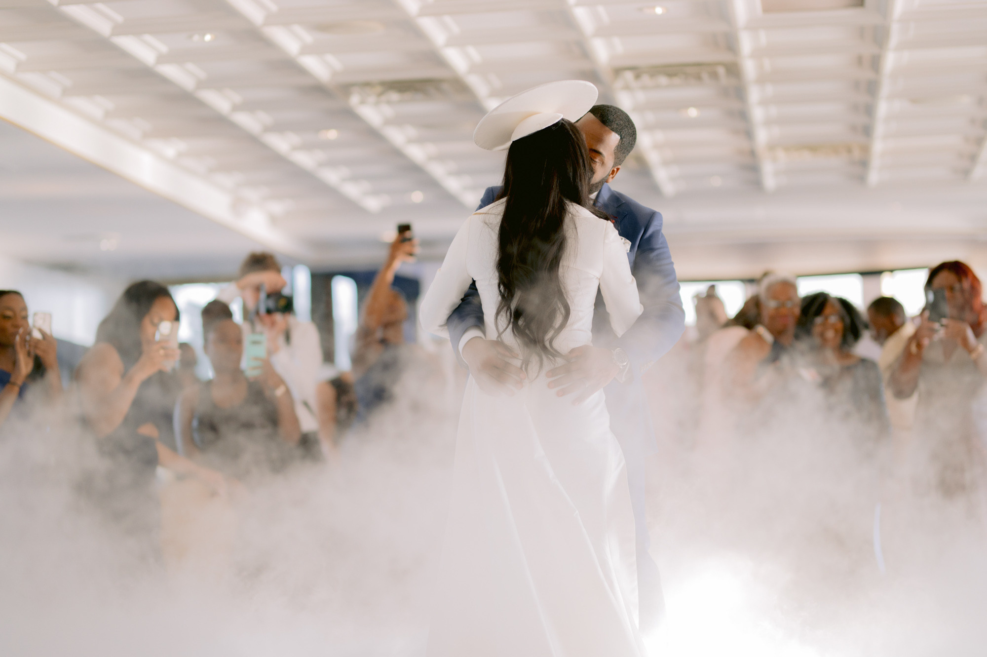 a woman in a white dress and hat standing in a room