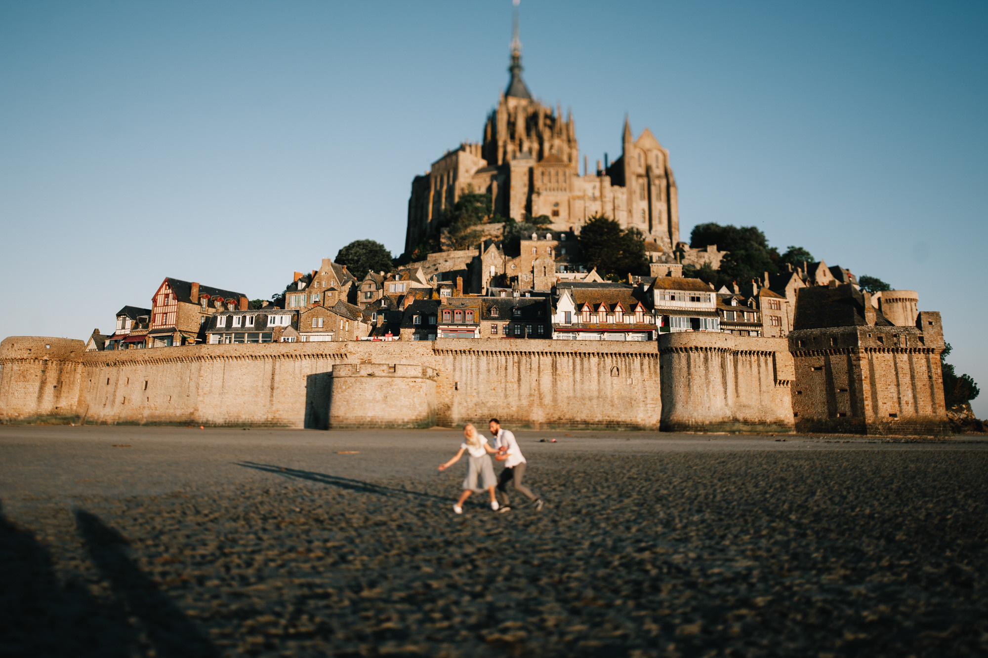 a man is walking on the beach with a kite