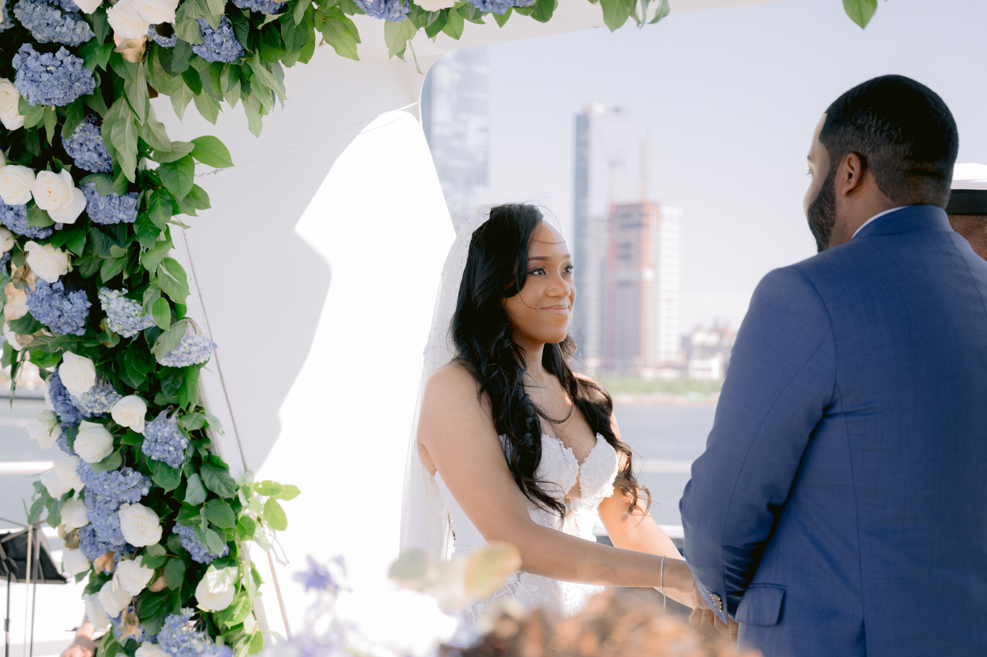 a bride and groom are standing under a floral arch