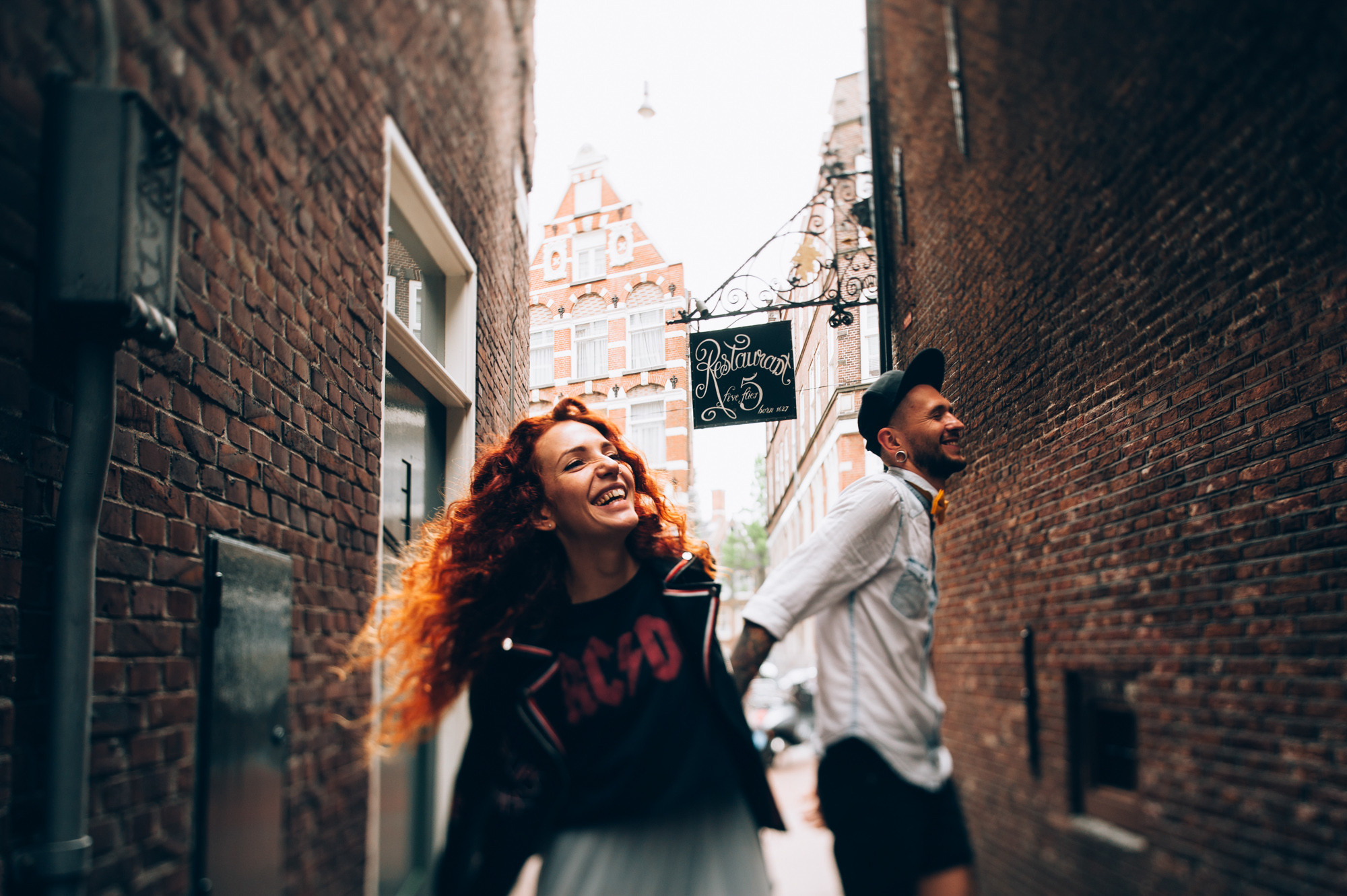 a man and woman walking down a narrow street