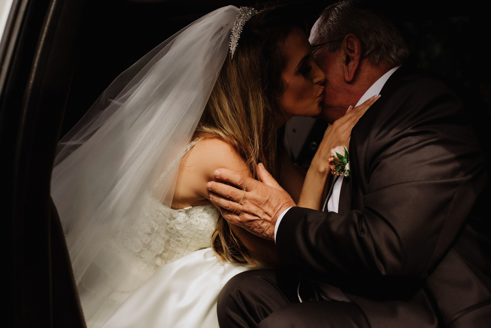 a bride and groom kissing in the back of a car