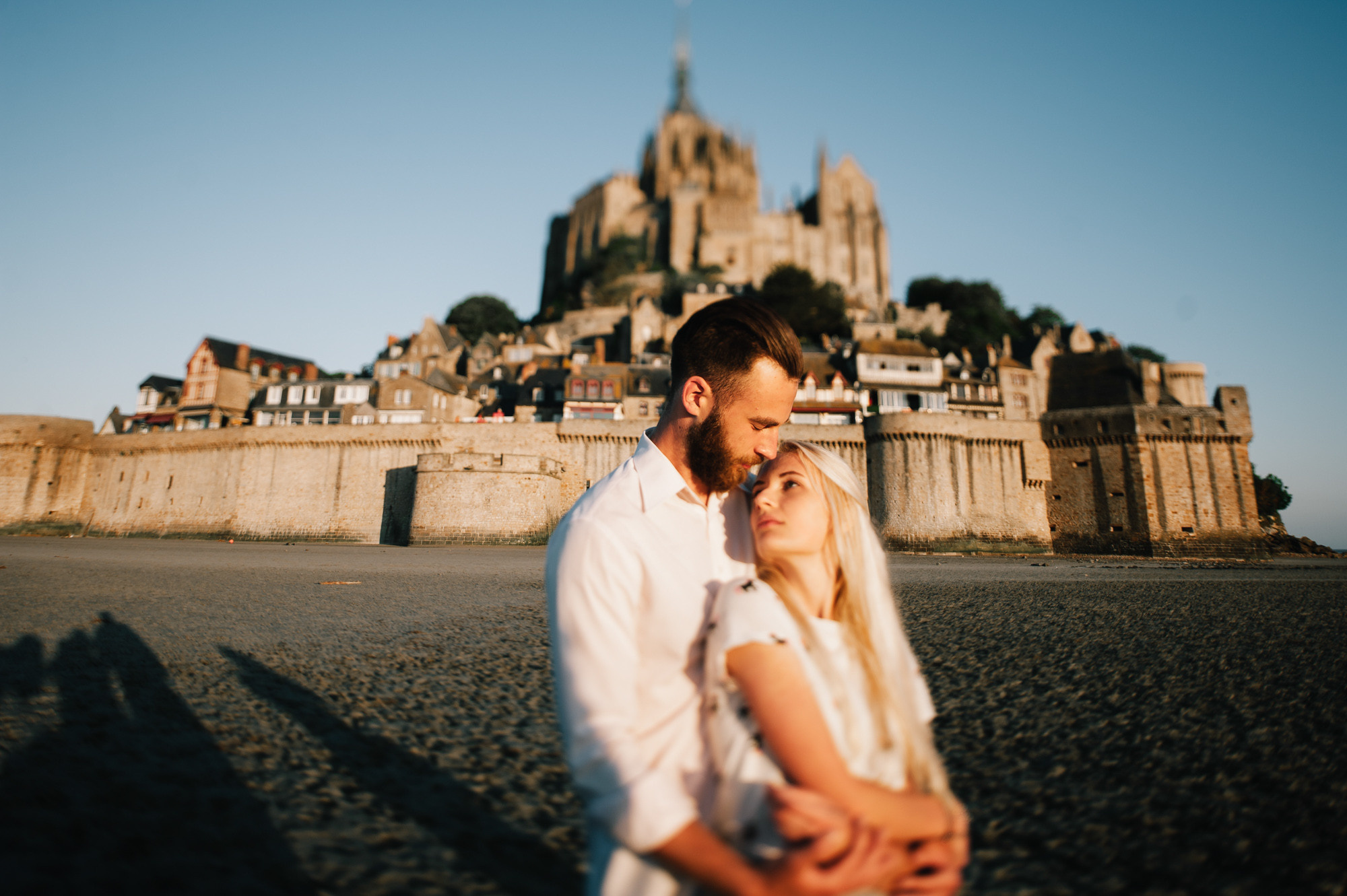 a man and woman are standing on the beach