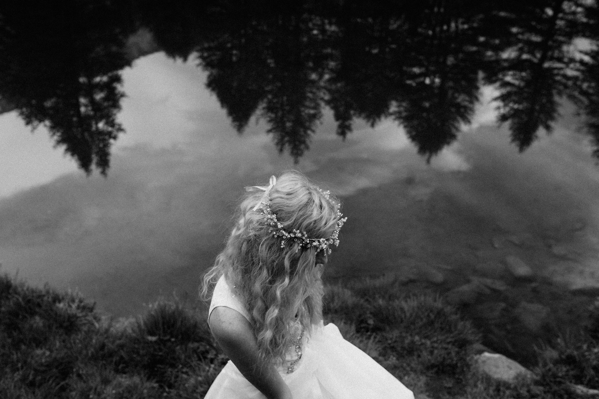 a woman in a wedding dress is standing on a hill