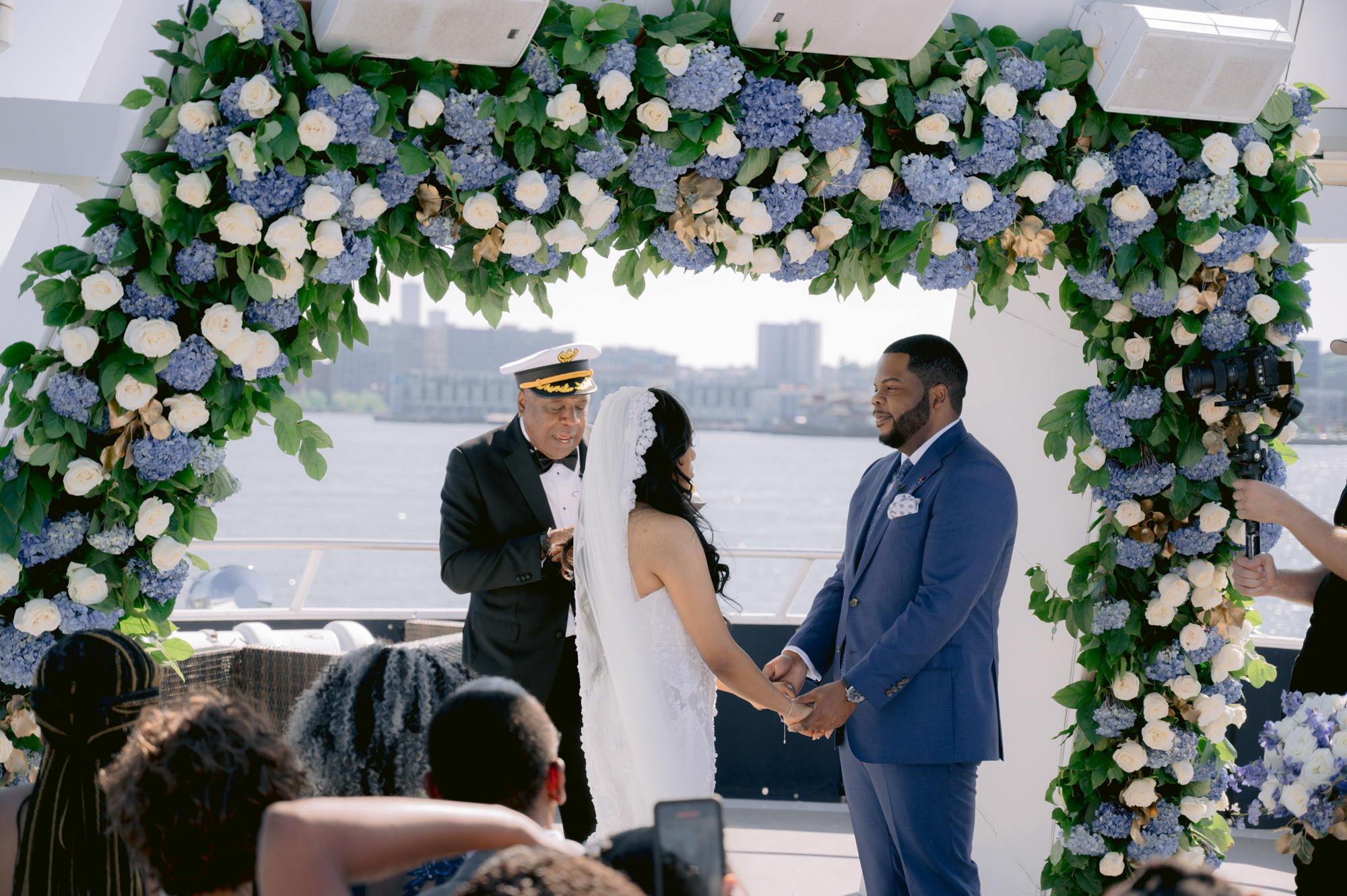 a man and woman are standing under a floral arch