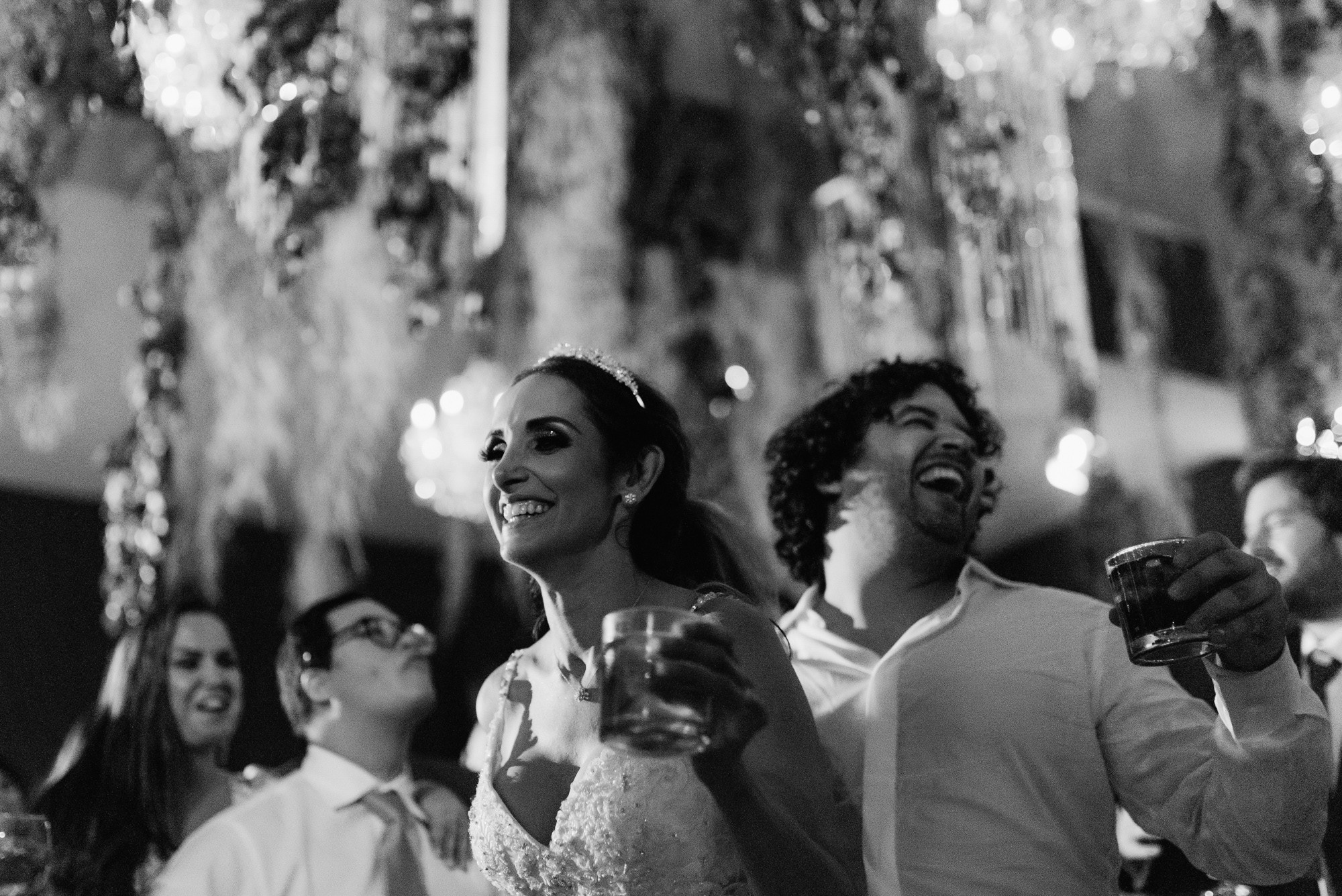 a couple is laughing and drinking wine at their wedding