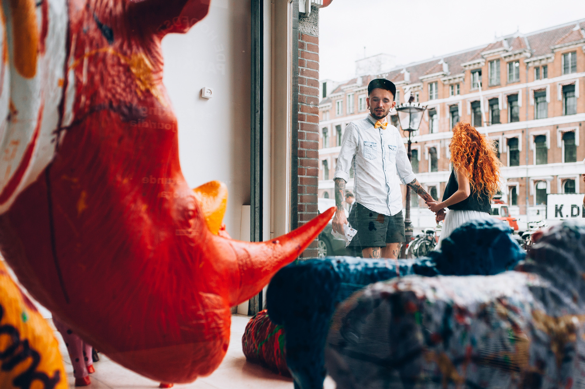 a man and woman standing in front of a window