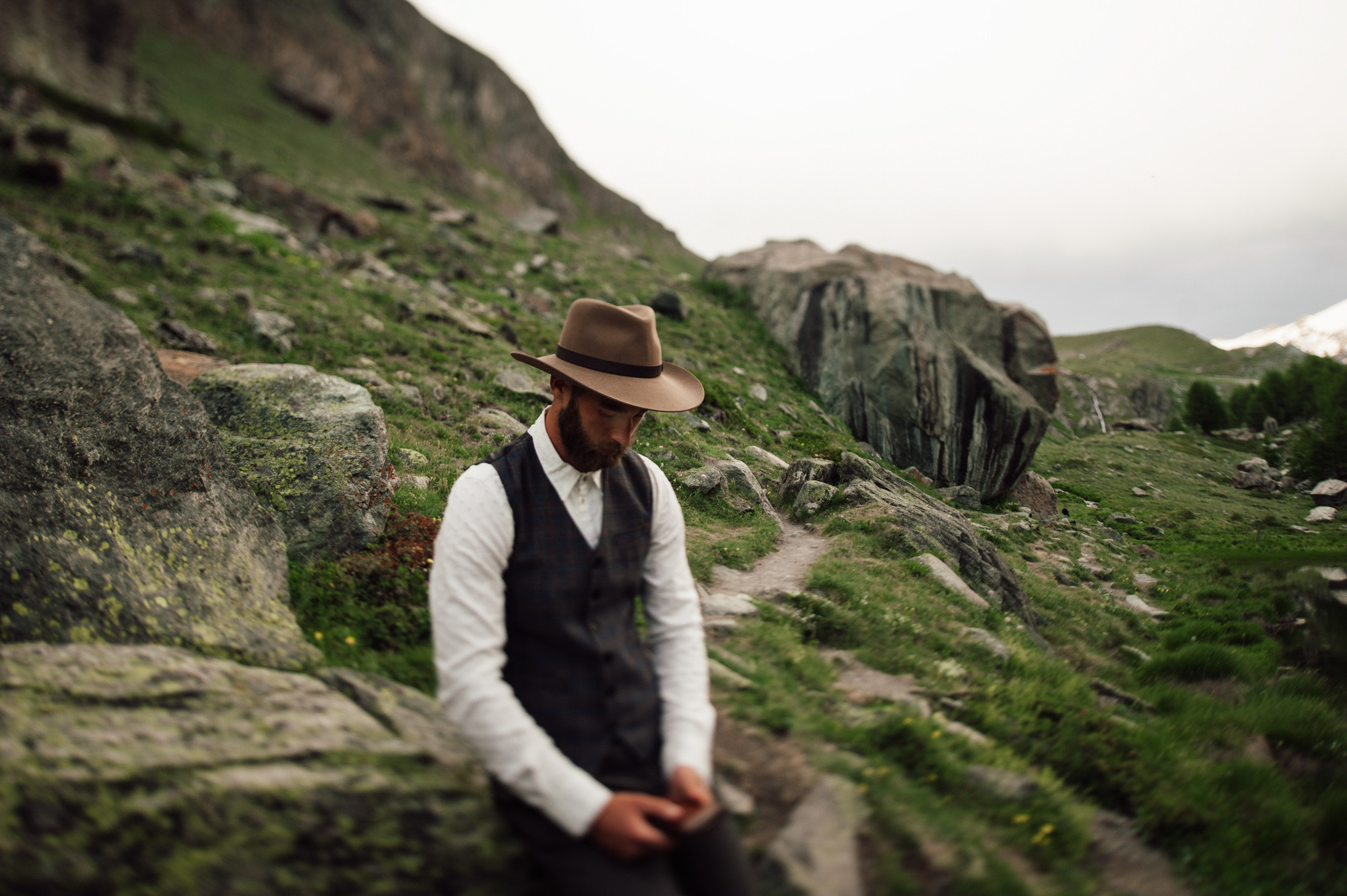 a man sitting on a rock in the mountains