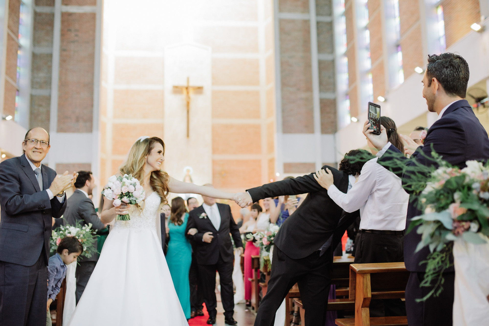 a bride and groom are taking pictures of each other people