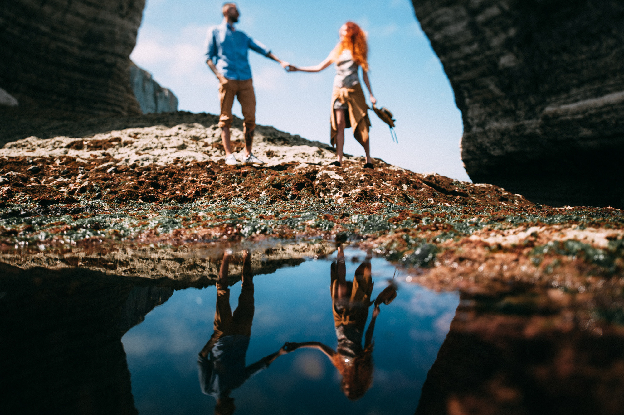 a couple holding hands walking through a tunnel