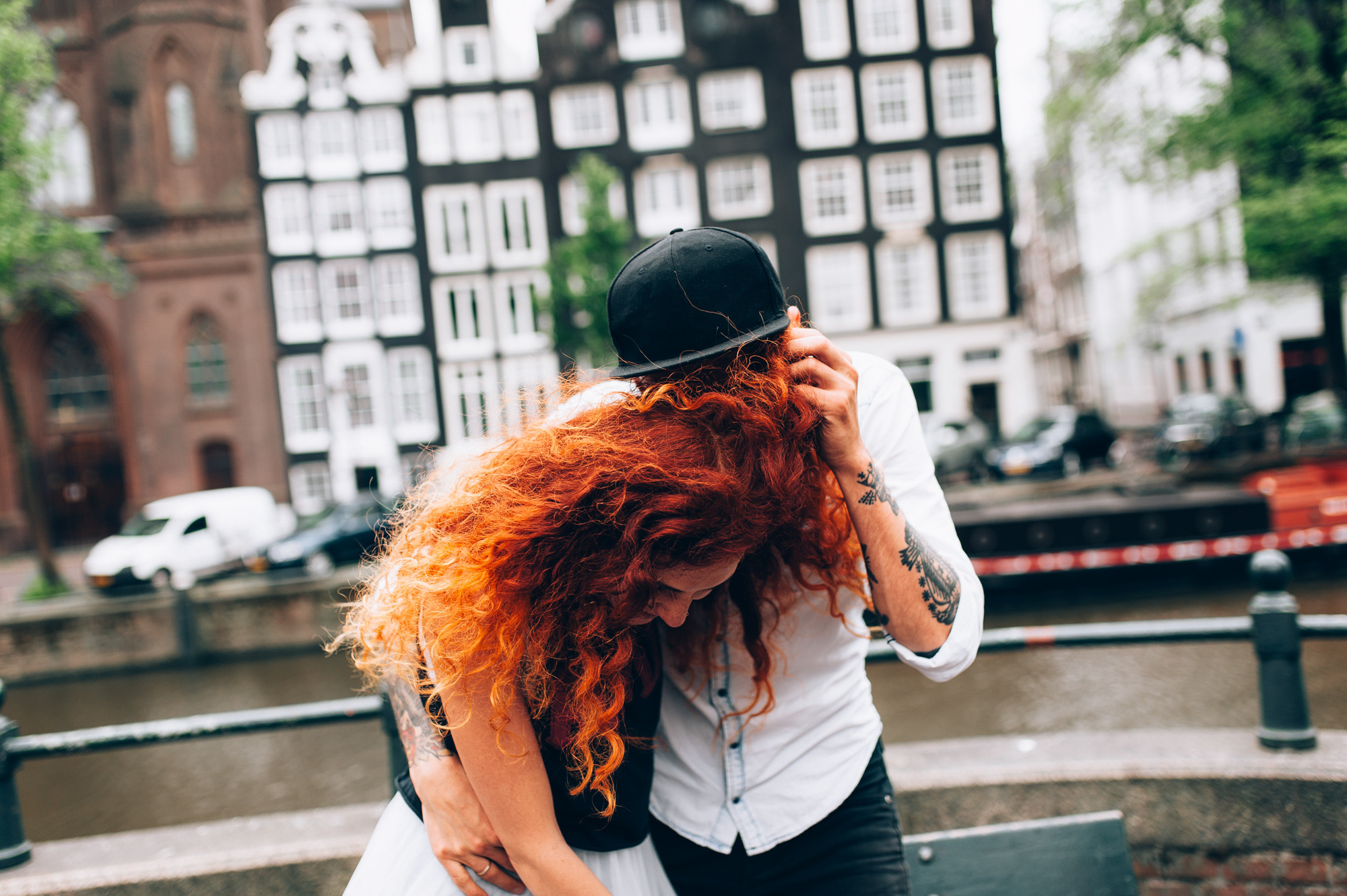 a woman with red hair is standing on a bridge