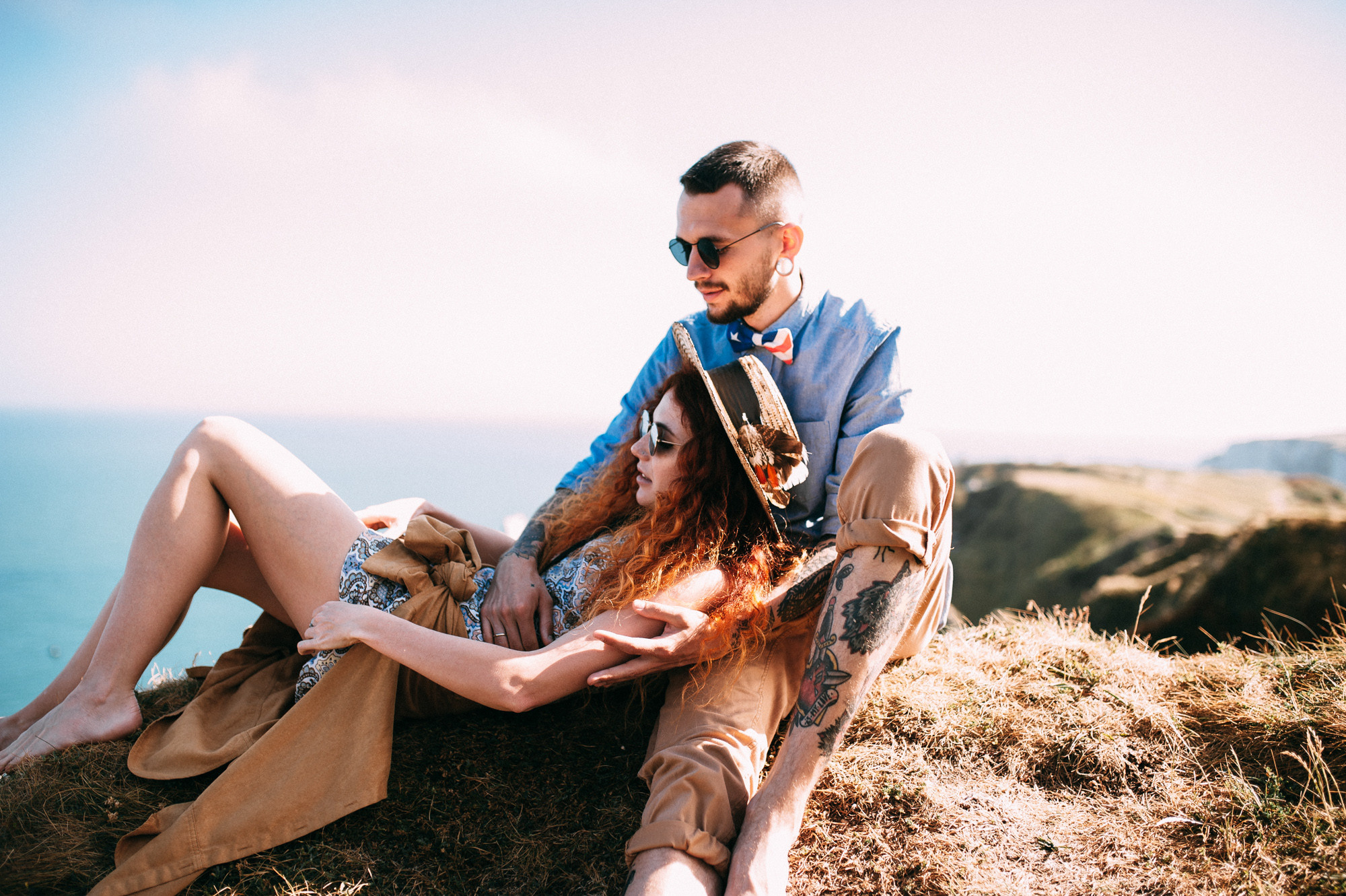 a man and woman sitting on a cliff