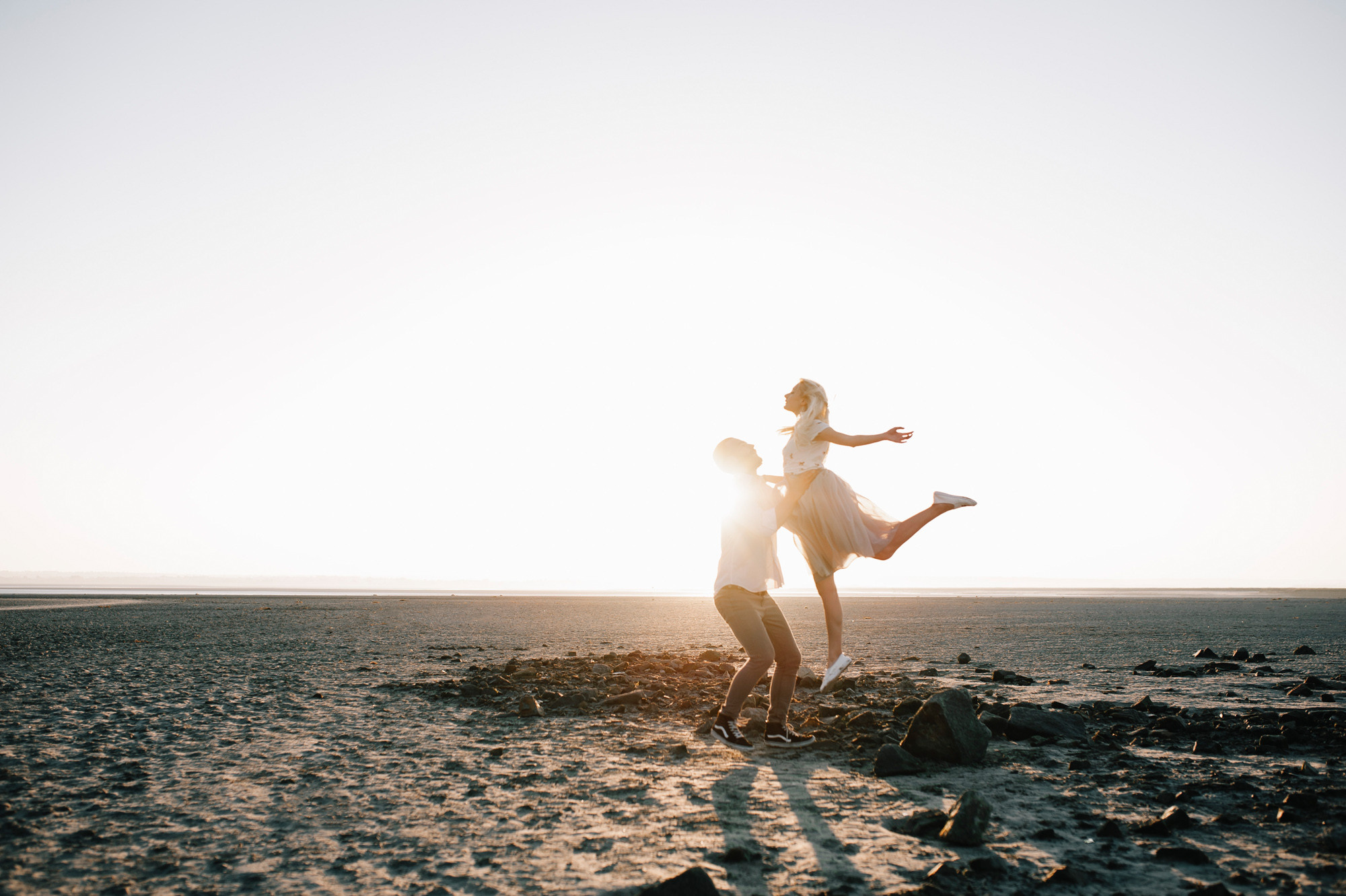 a woman standing on a beach holding a froth
