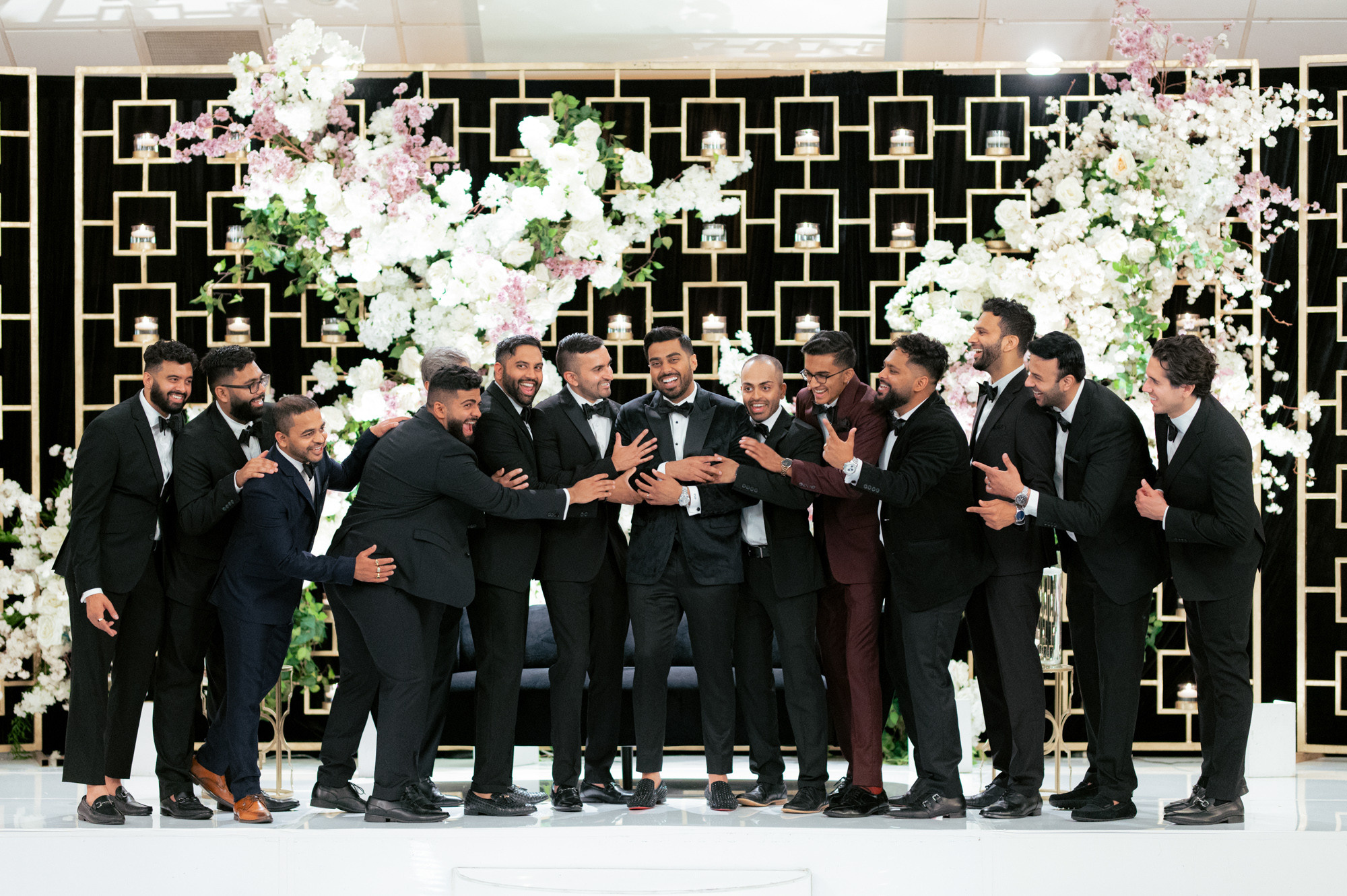 a group of men in tuxed suits posing for a picture