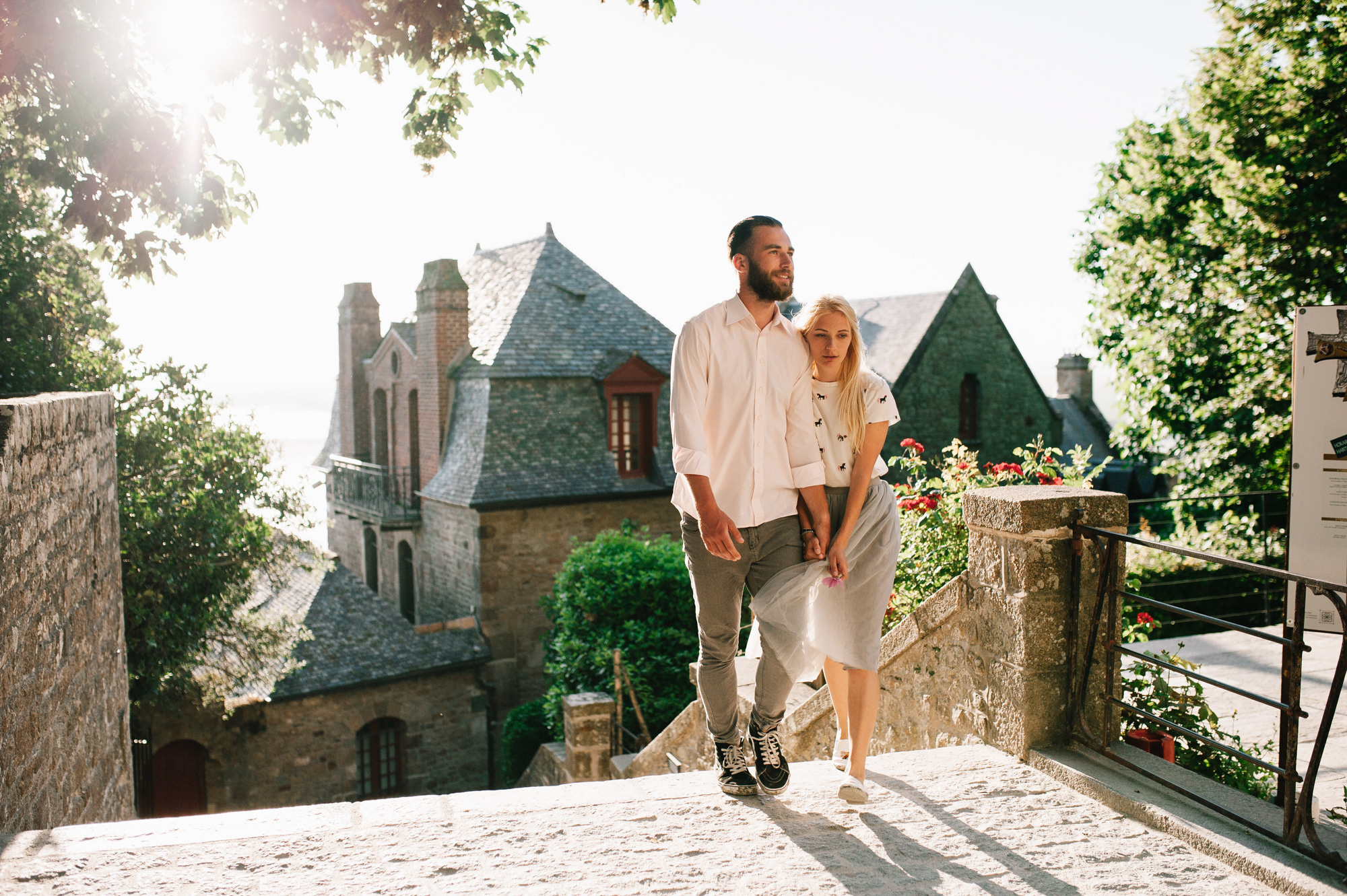 a man and woman walking down a stone walkway