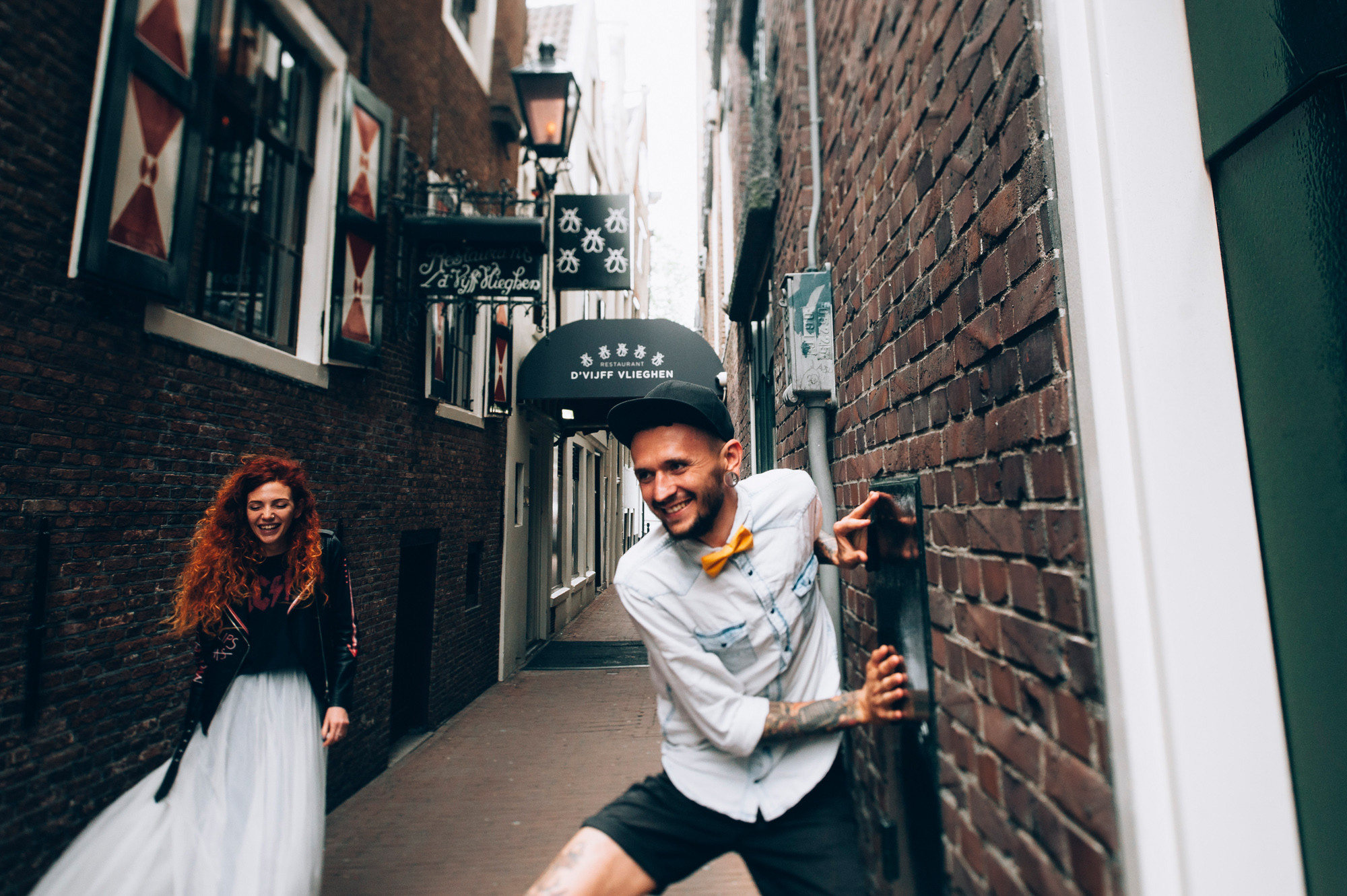 a man and woman walking down a narrow street