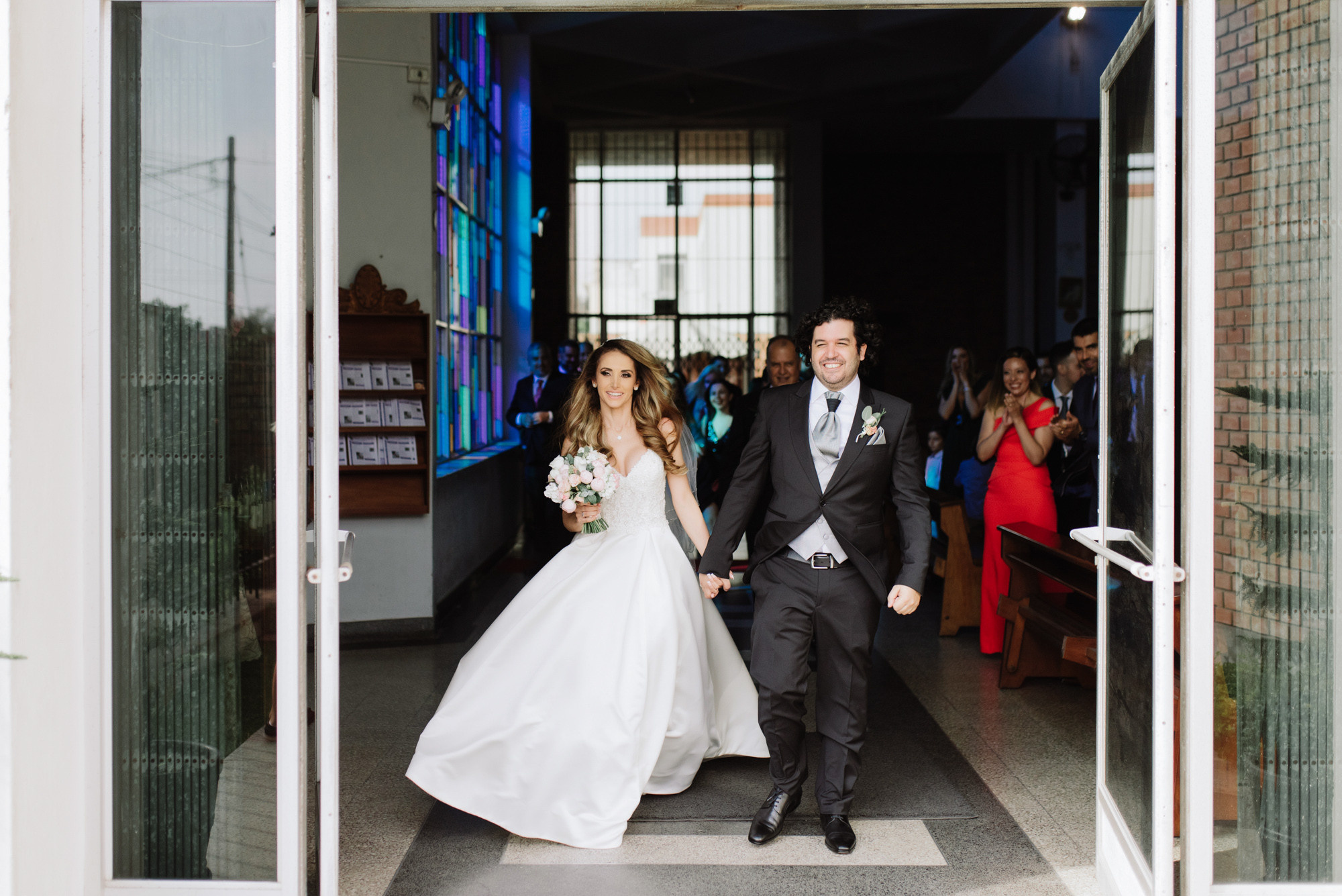 a bride and groom walking out of a church