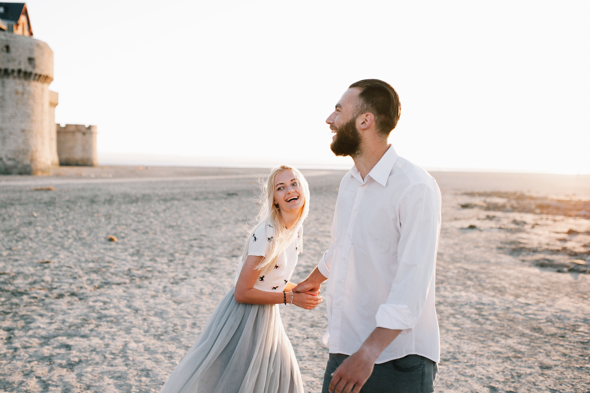 a man and woman standing on a beach