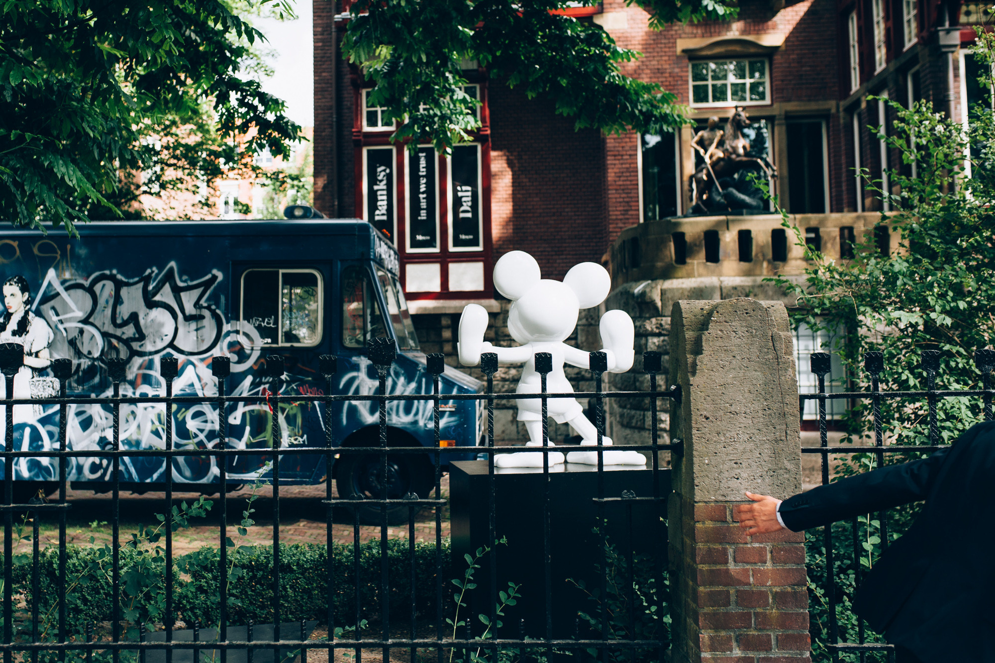 a man standing in front of a fence with a van