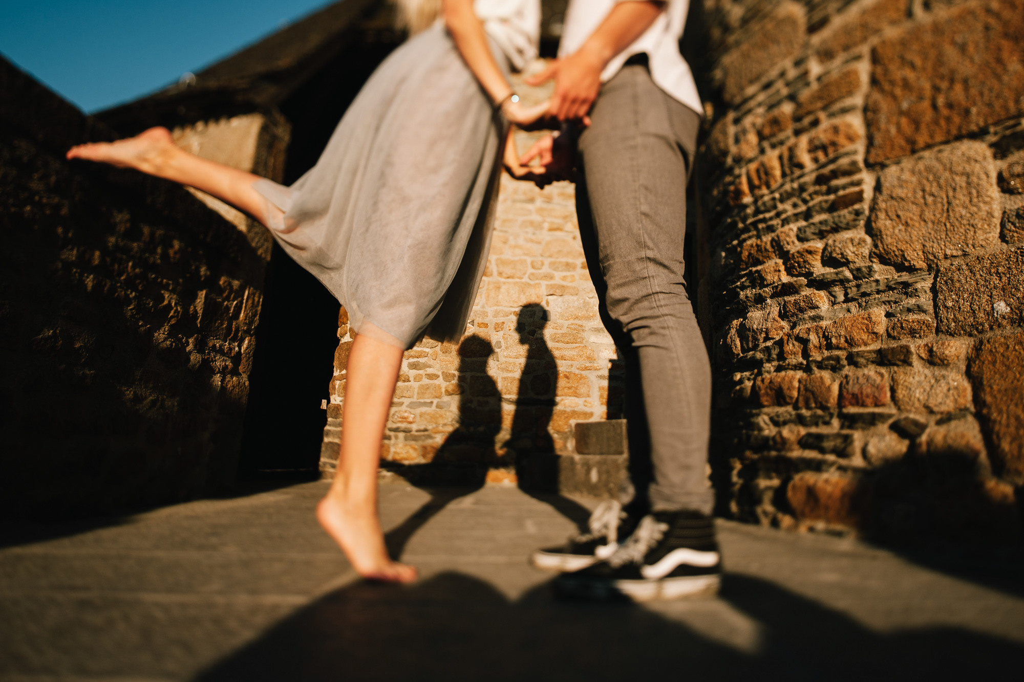 a couple standing on a stone wall