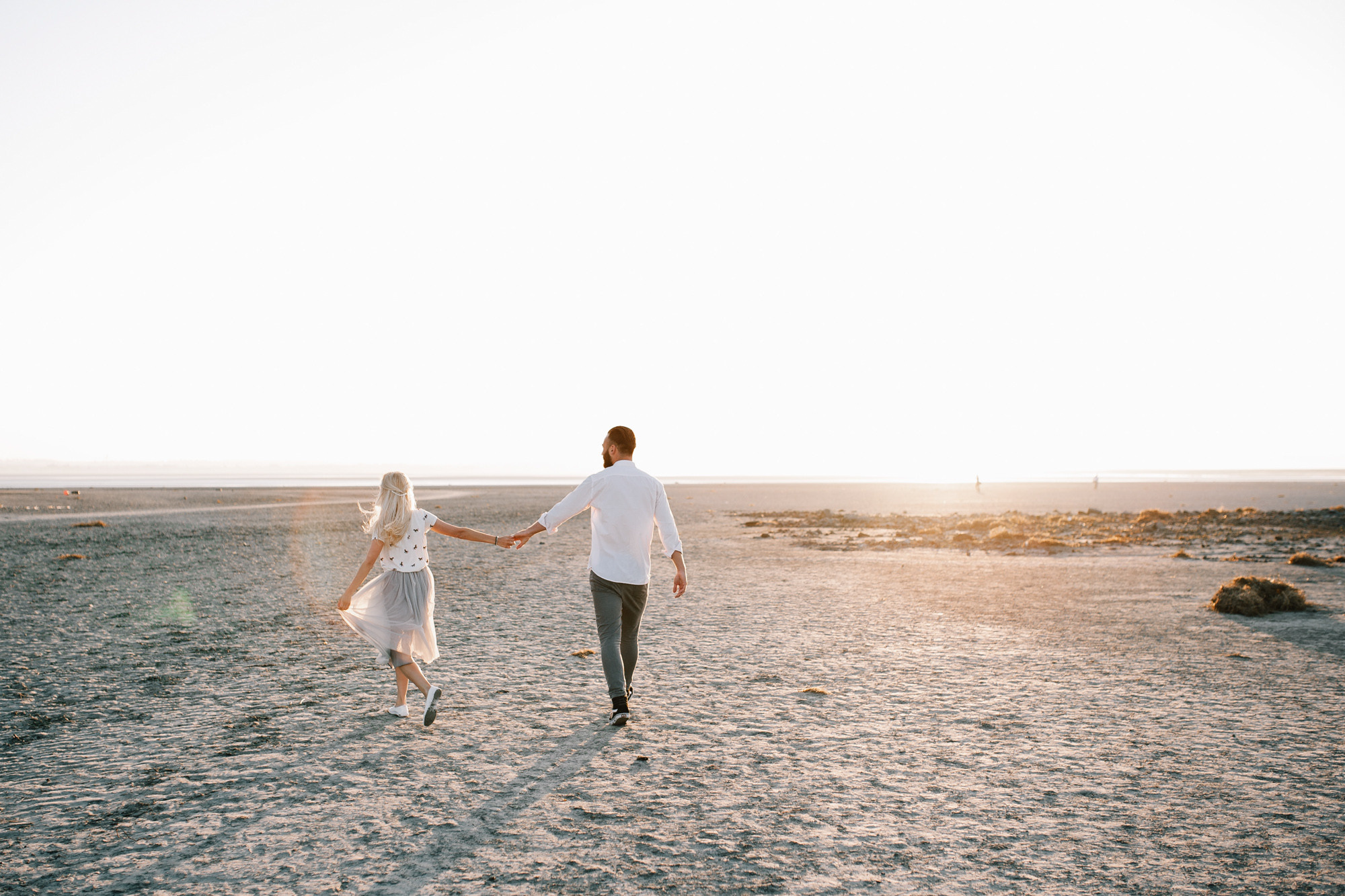 a man and woman walking on a beach