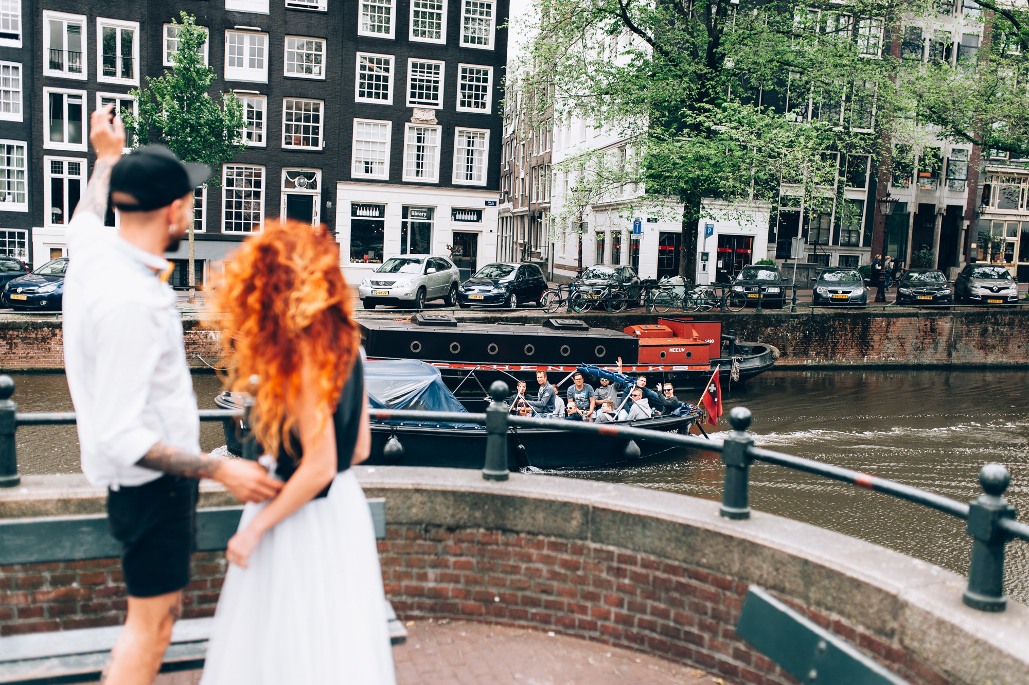 a couple standing on a bridge looking at a canal