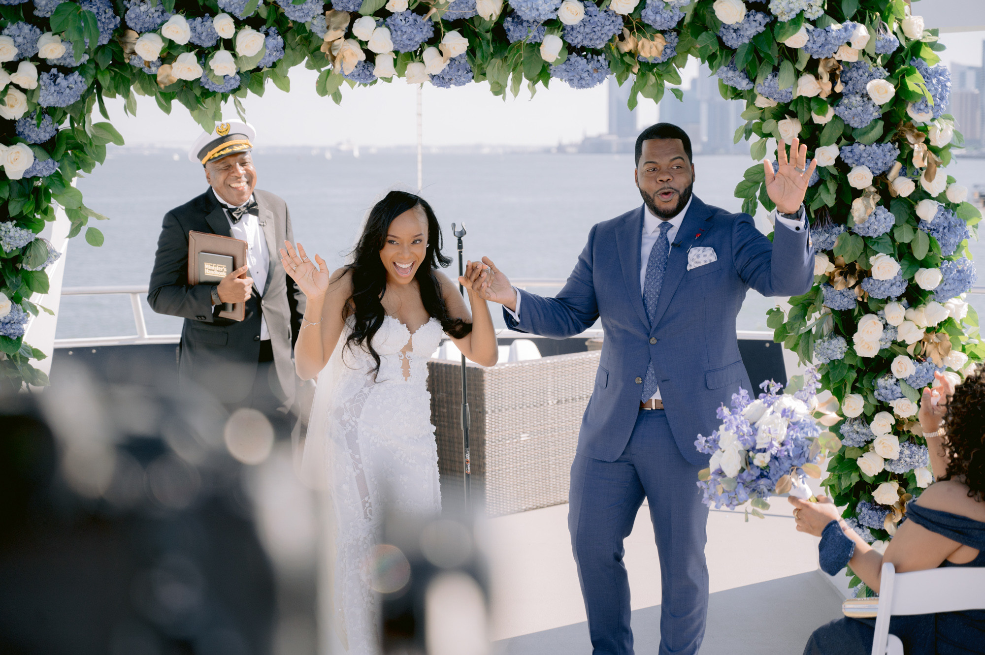 a man and woman are standing under a floral arch