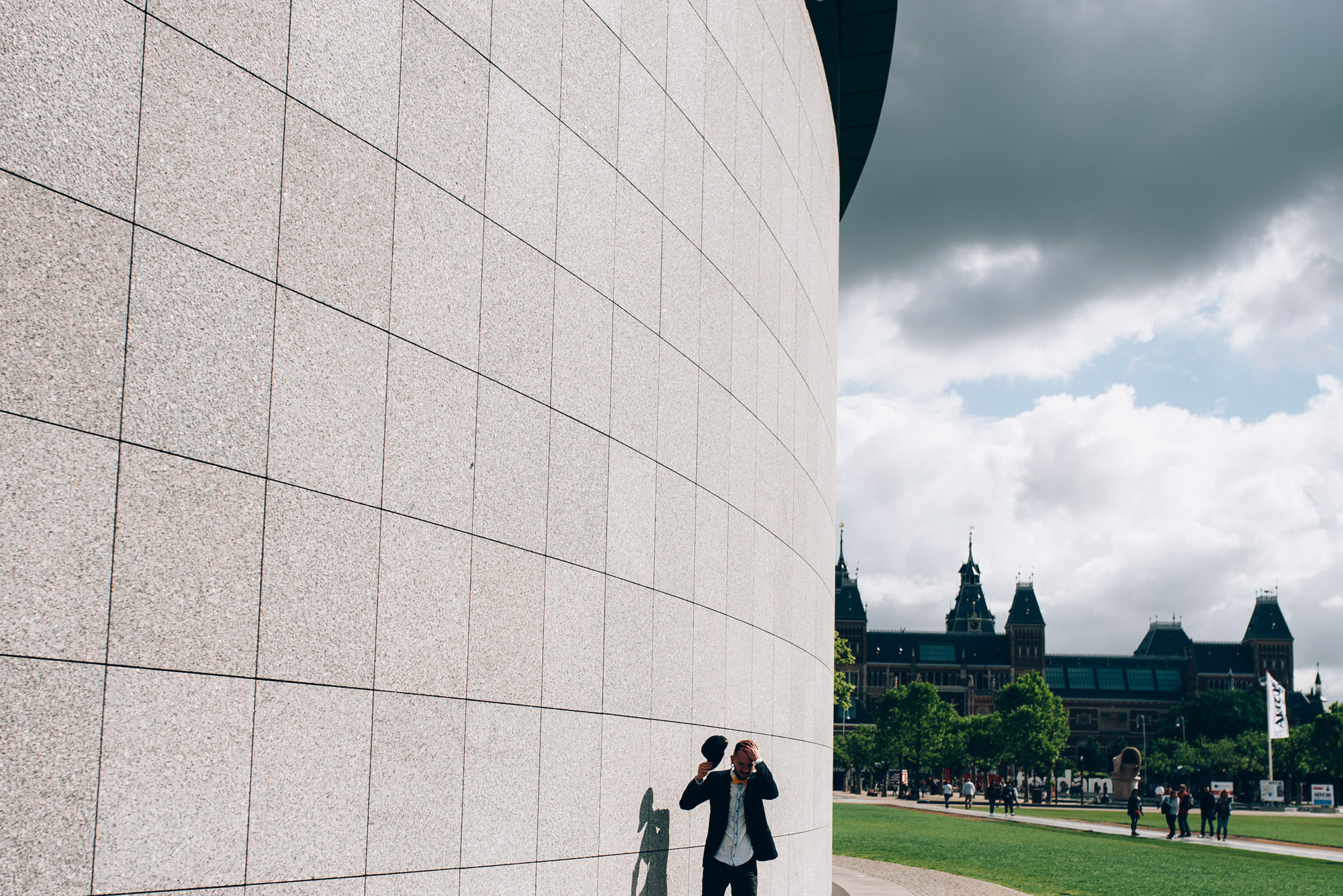 a man standing next to a wall with a cell in his hand
