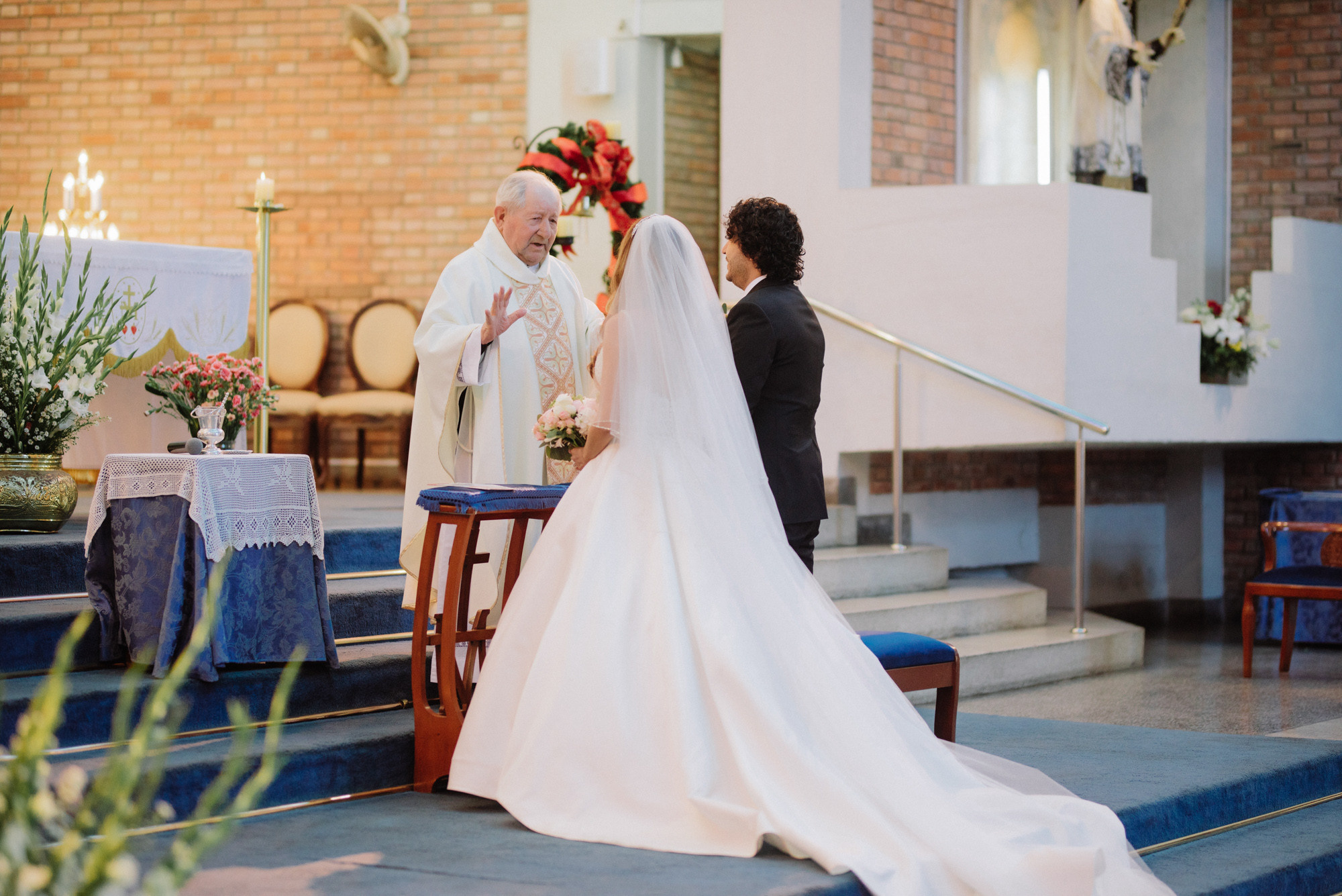 a bride and groom are kneeling at the alter